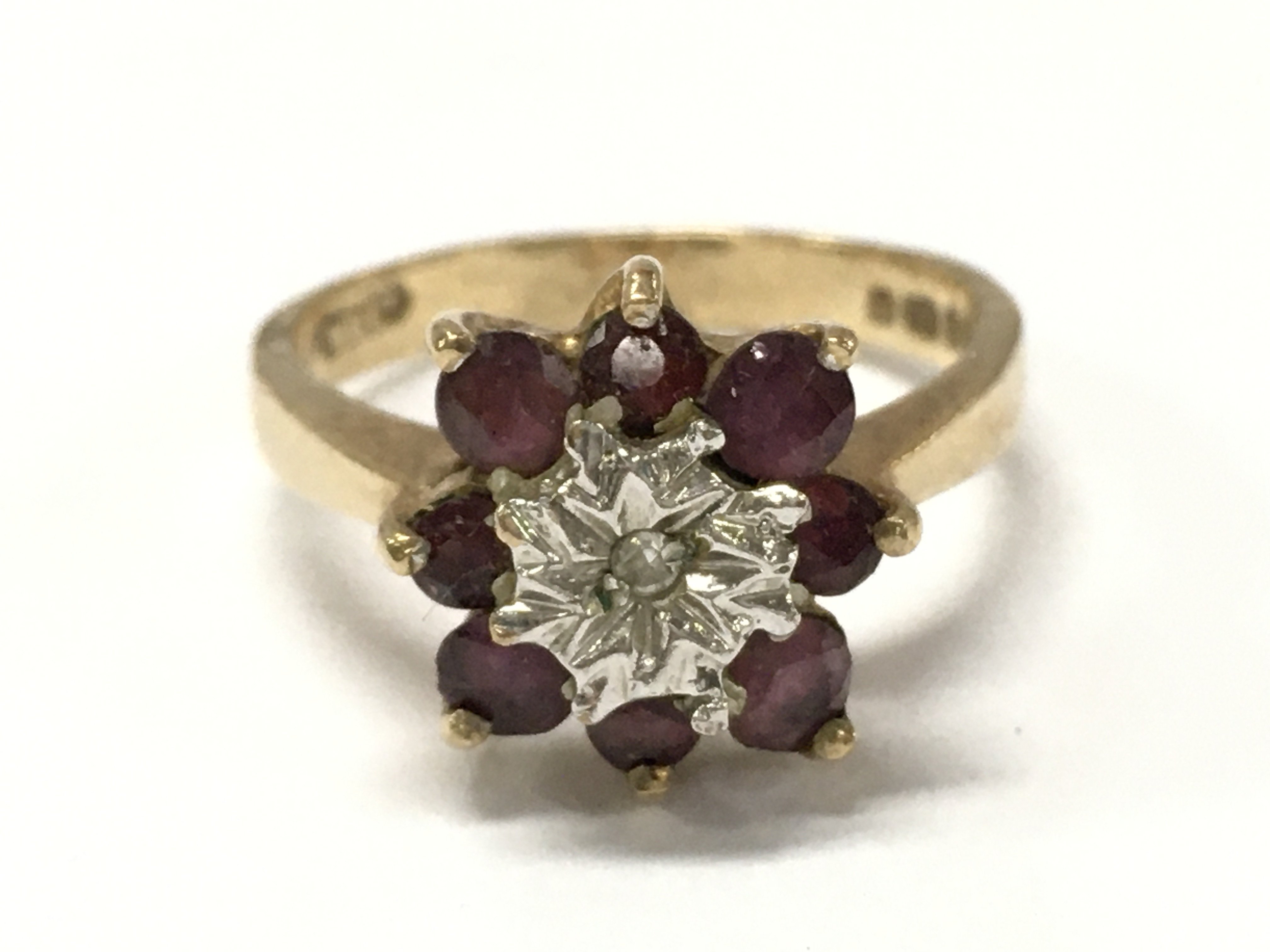 A 9ct gold ring set with a pattern of ruby and chip diamonds , 3.1g total weight. Size M. Postage category A