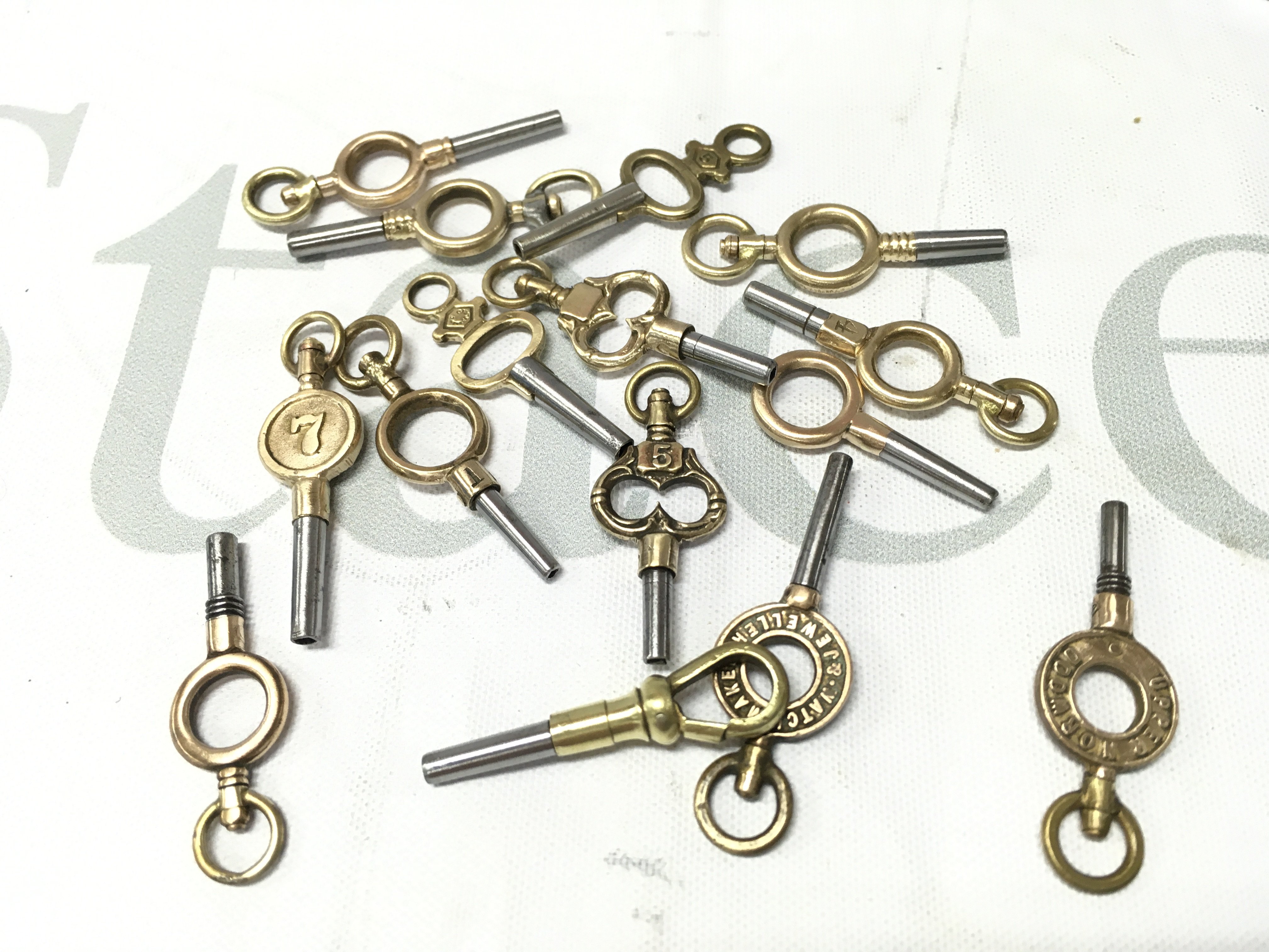 Fifteen vintage pocket watch keys . Postage cat a