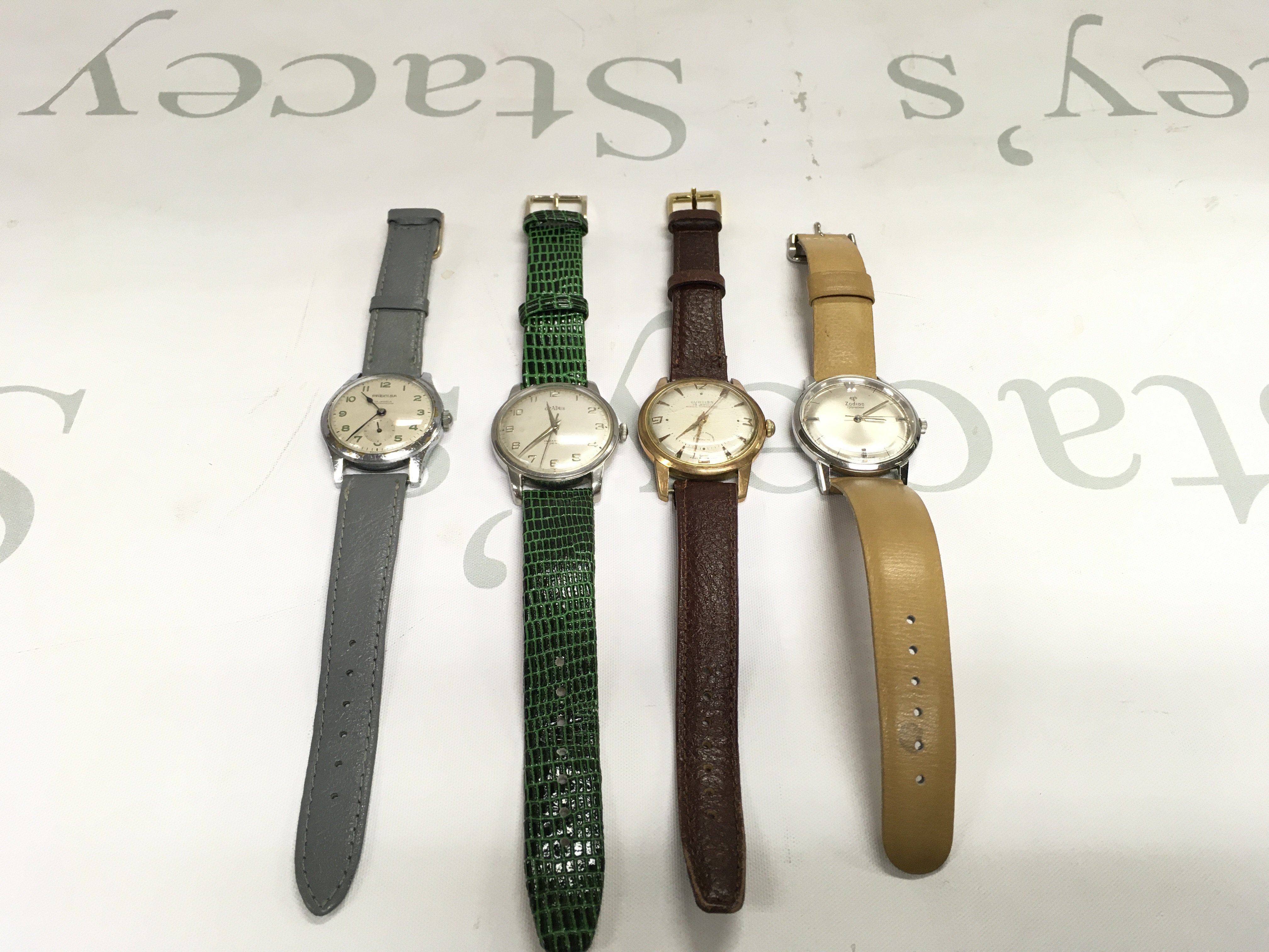 A Collection of four vintage gents wrist watches. Including Zodiac Curtiss etc. All wind and seen running.
