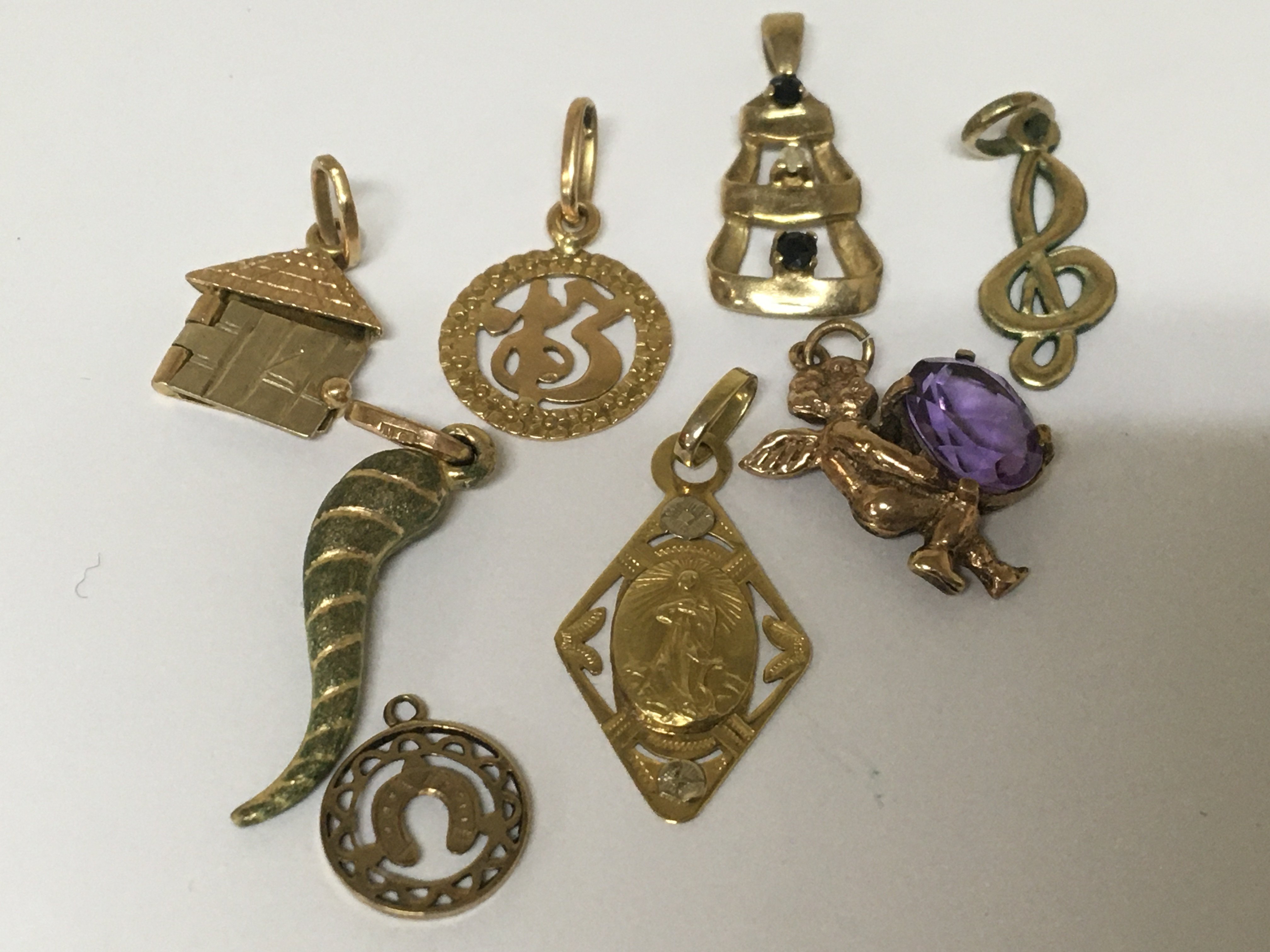 A collection of gold charms and pendents. Weight 8g