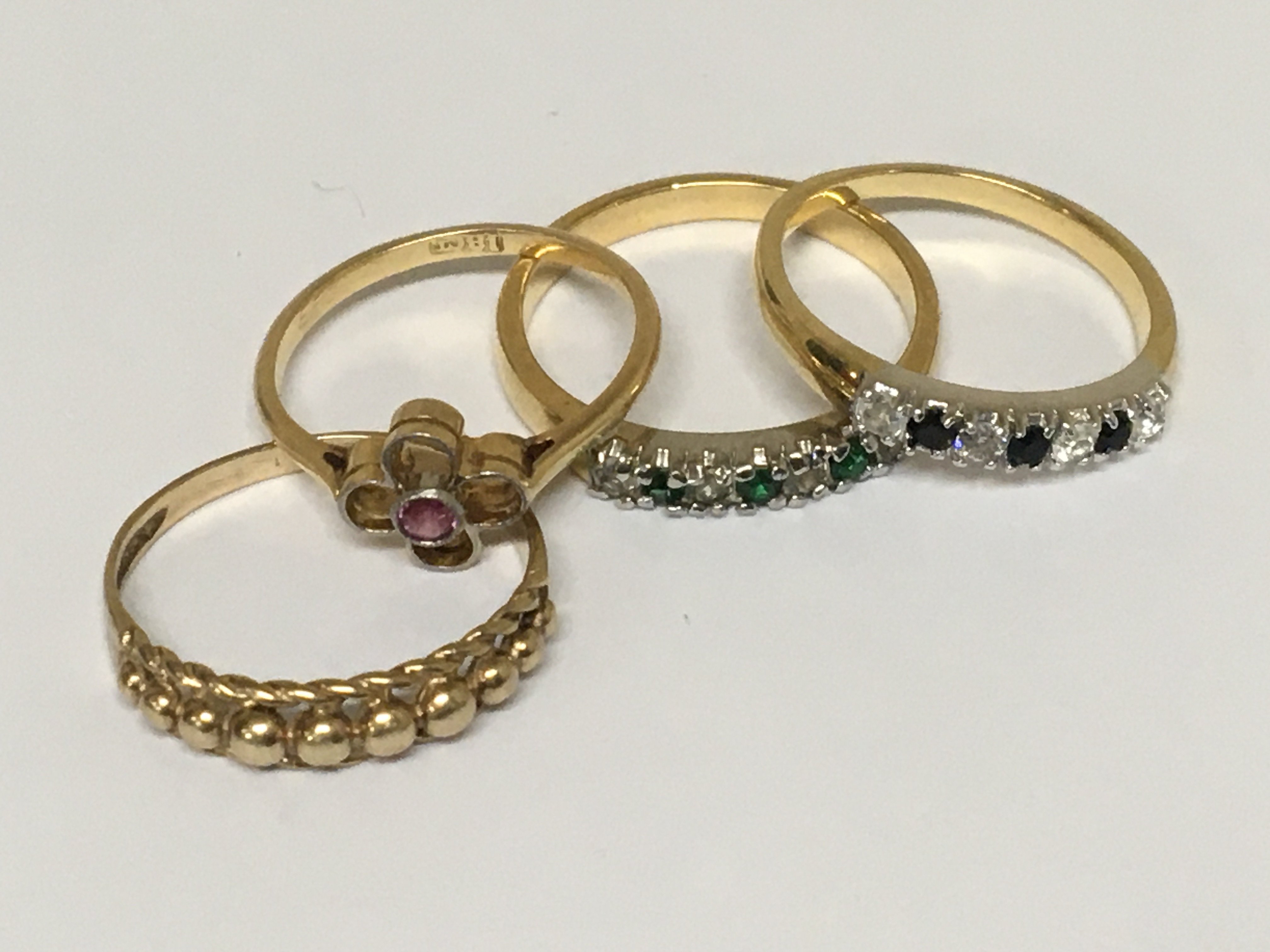 An 18cart gold ring set with a ruby weight 1.8g two matching unmarked rings set with alternating stones and a 9carat gold ring 1.5g