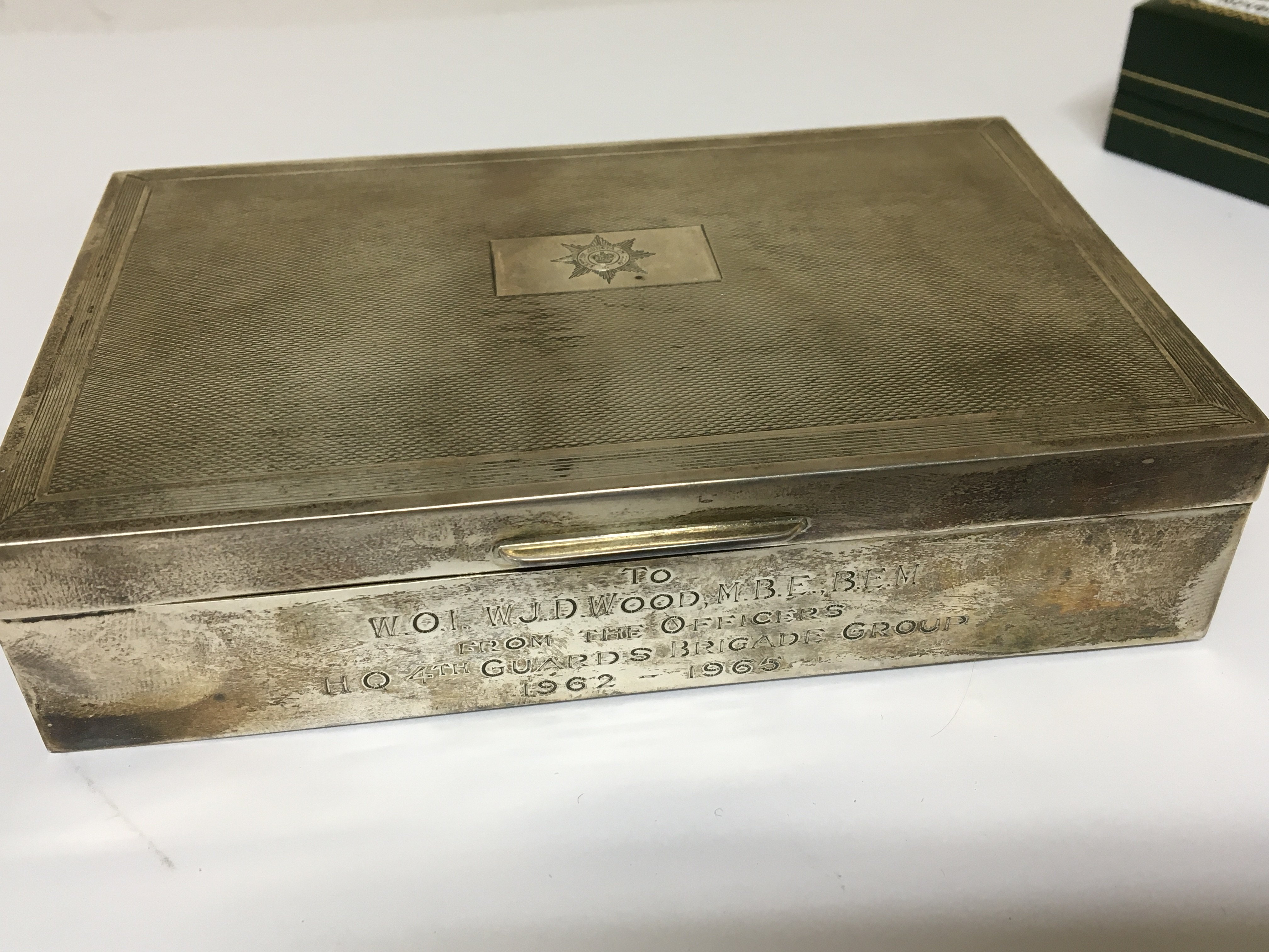 A silver cigarette box of rectangular shape with personal inscription.
