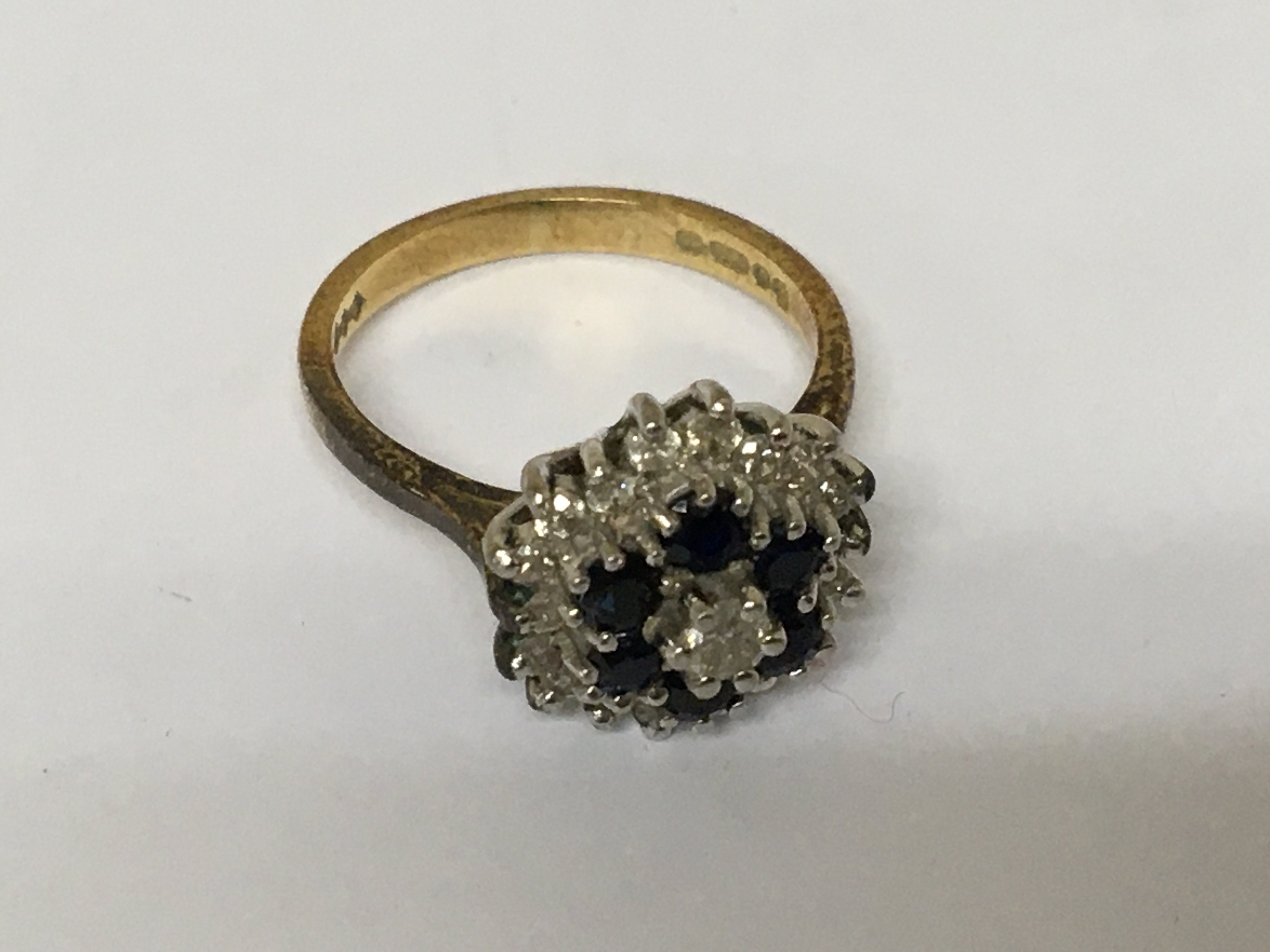 A ladies 18carat gold ring set with a pattern of diamonds and sapphire. Weight 4.4g