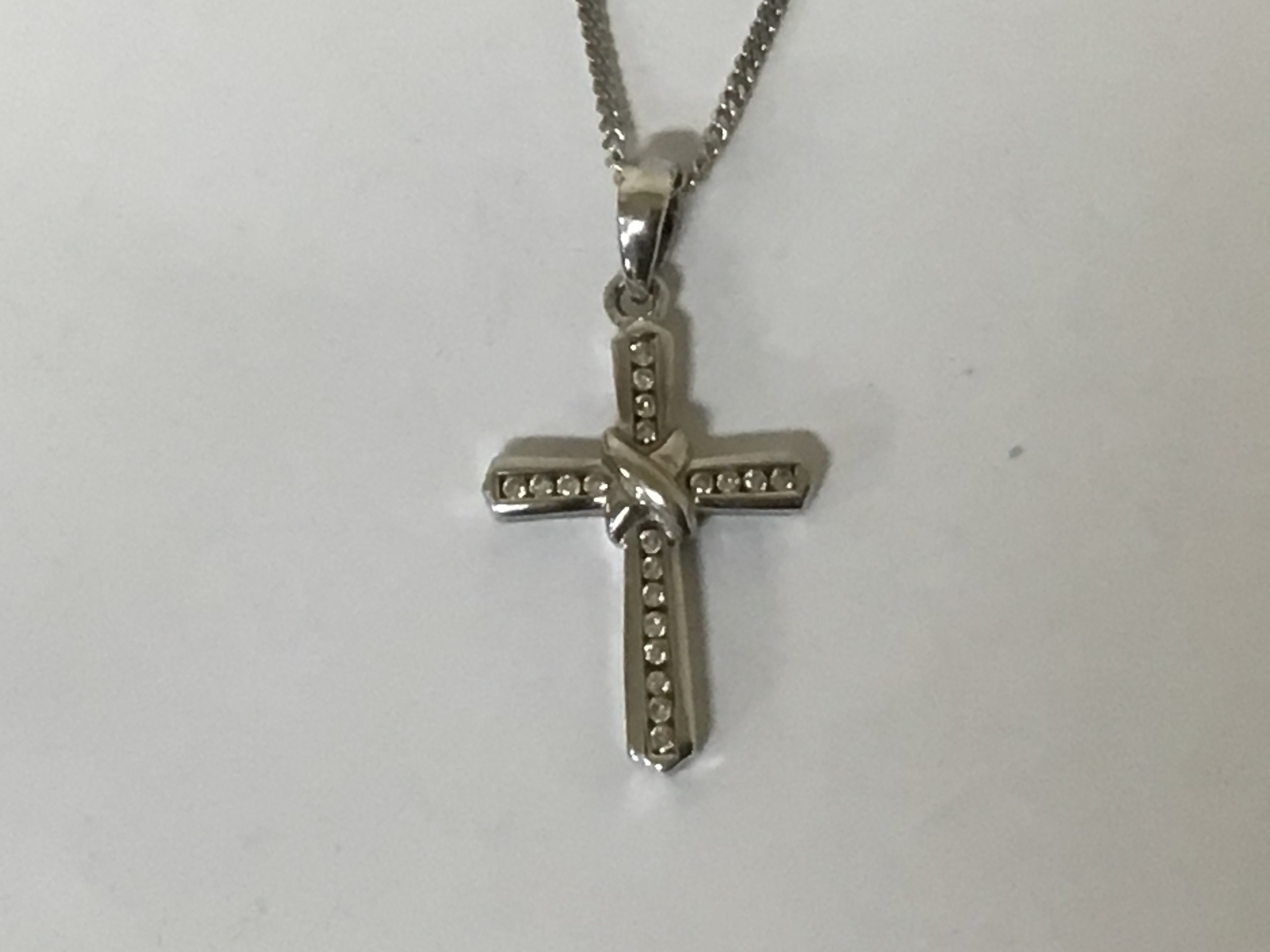 An 18carat white gold pendant set with a pattern of diamonds weight 4g on a 9carat white gold chain 3.5g