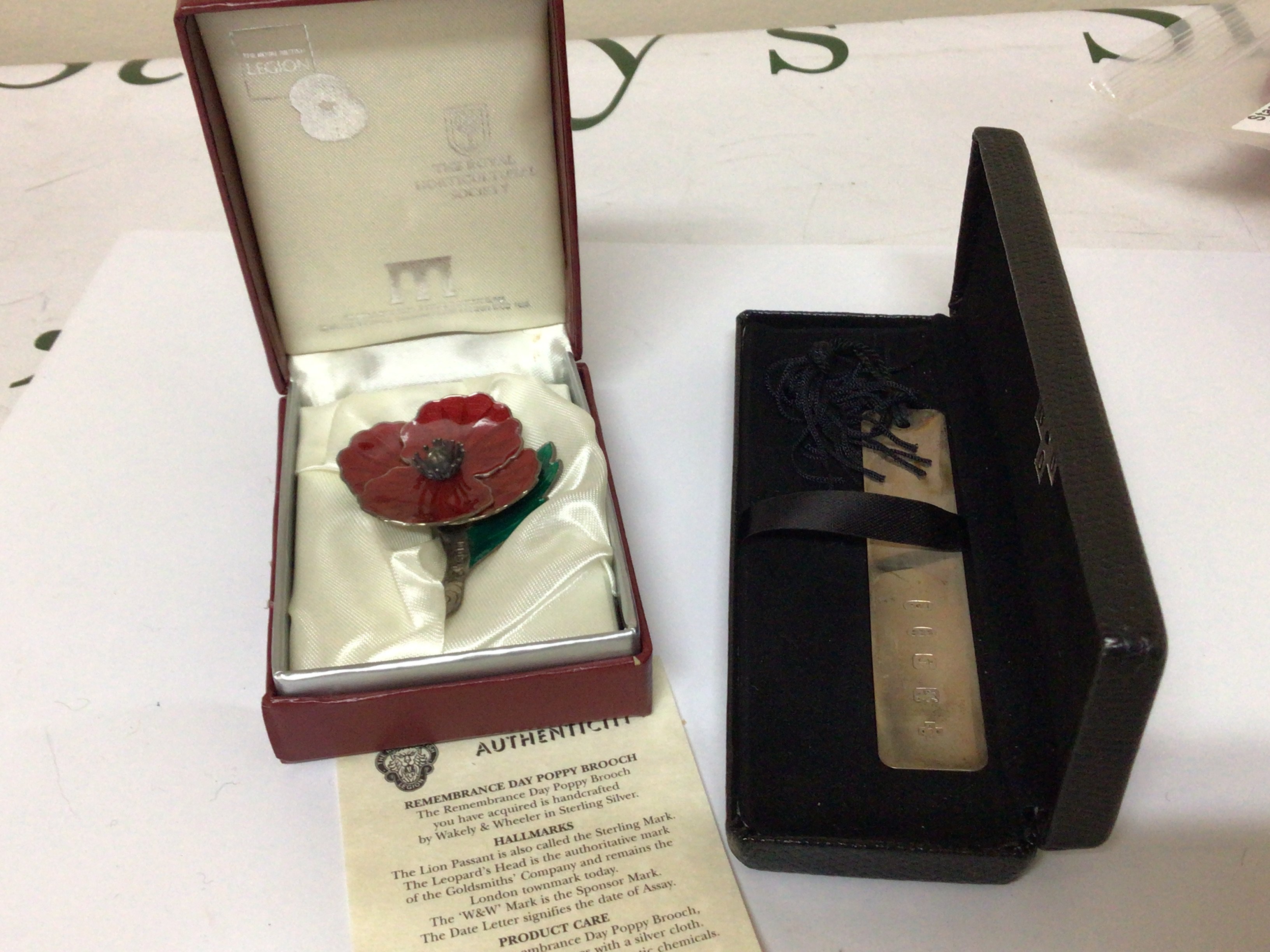 A silver and enamel Remembrance Day Poppy and a silver book mark both in presentation boxes, (2)