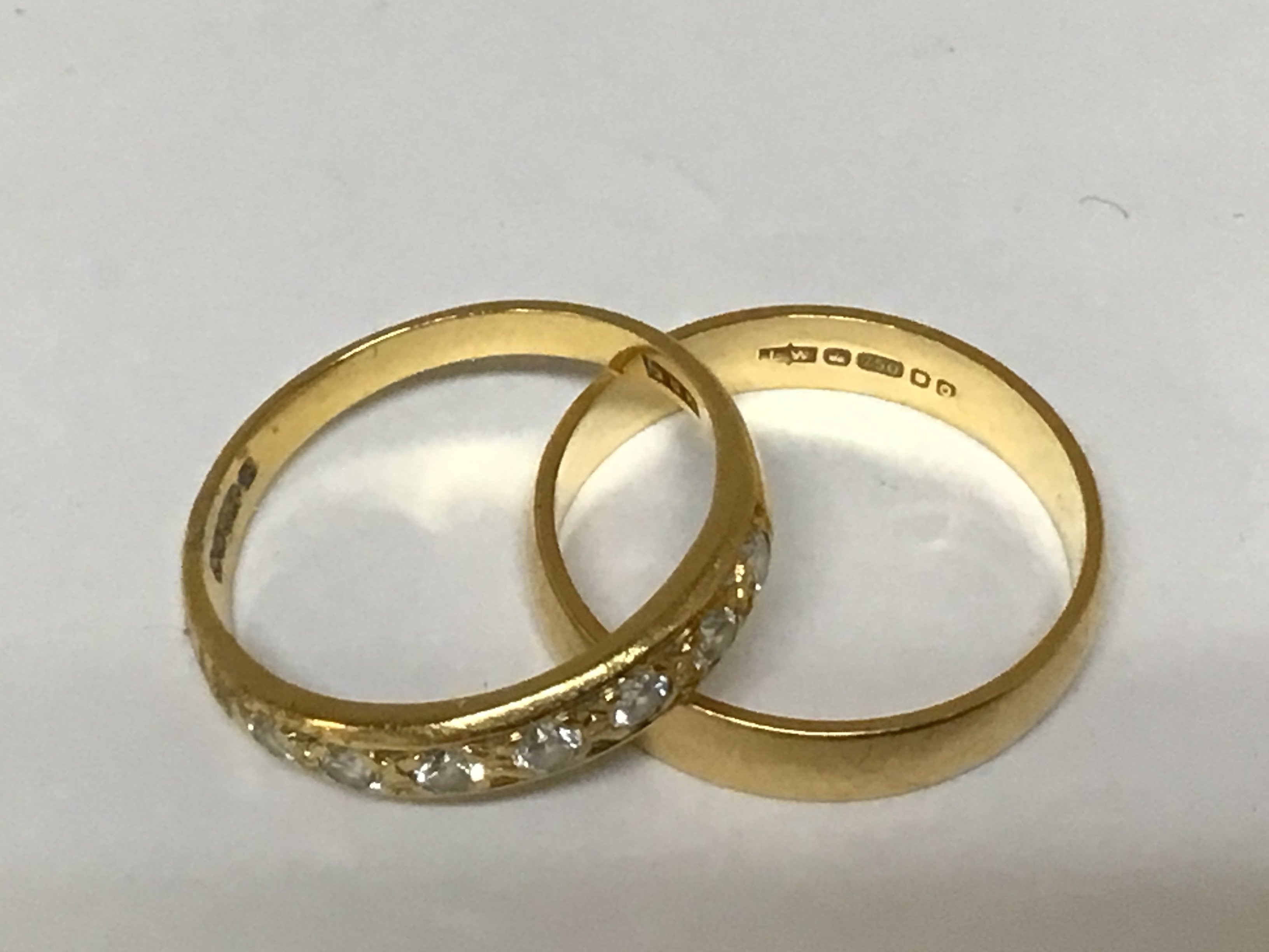 An 18carat gold wedding band weight 2.9g and one other gold ring set with seven small round brilliant cut diamonds.