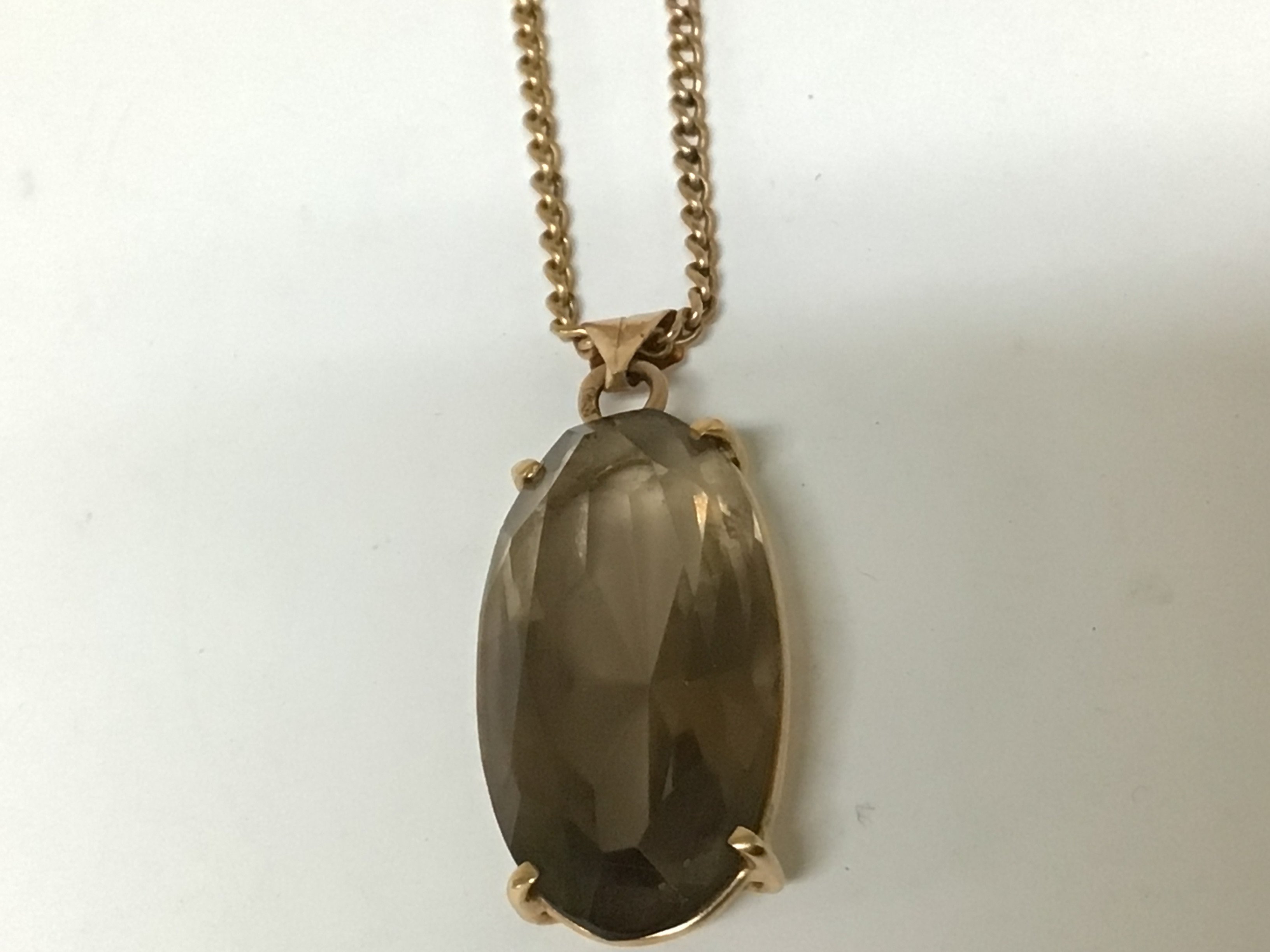 A Fifteen carat gold pendant set with smoked quartz with an attached gold chain total weight 10.5g