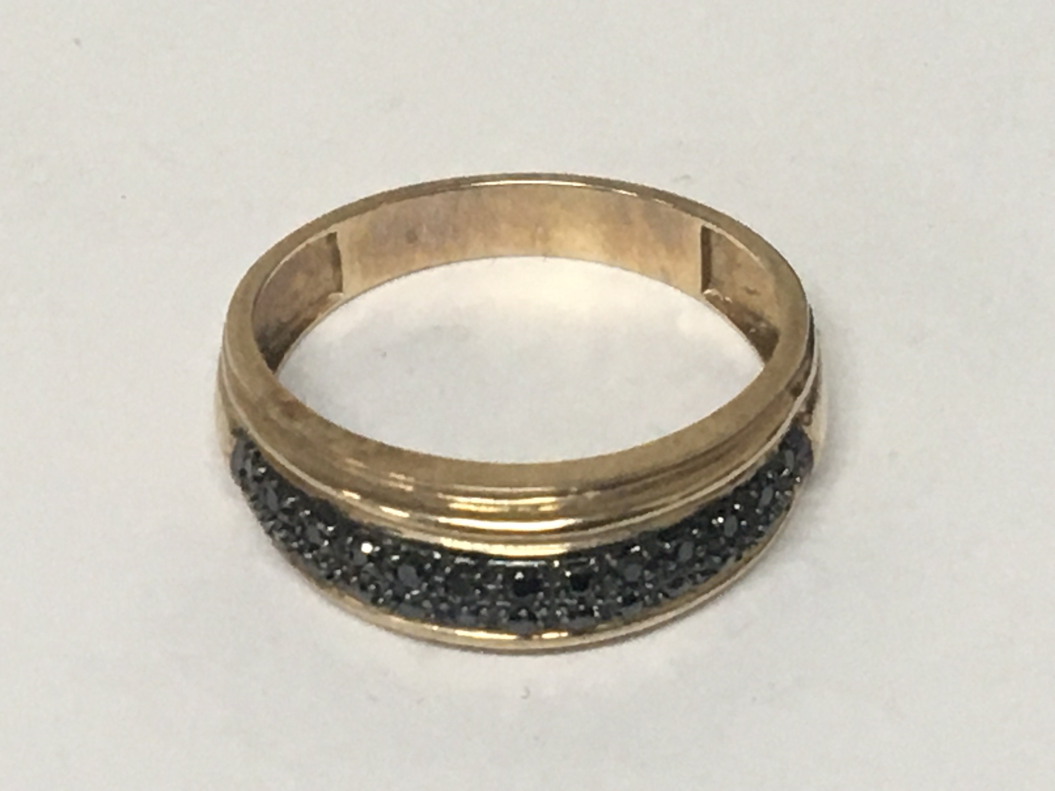 A 9carat gold ring set with a pattern of black diamonds. Weight 3g