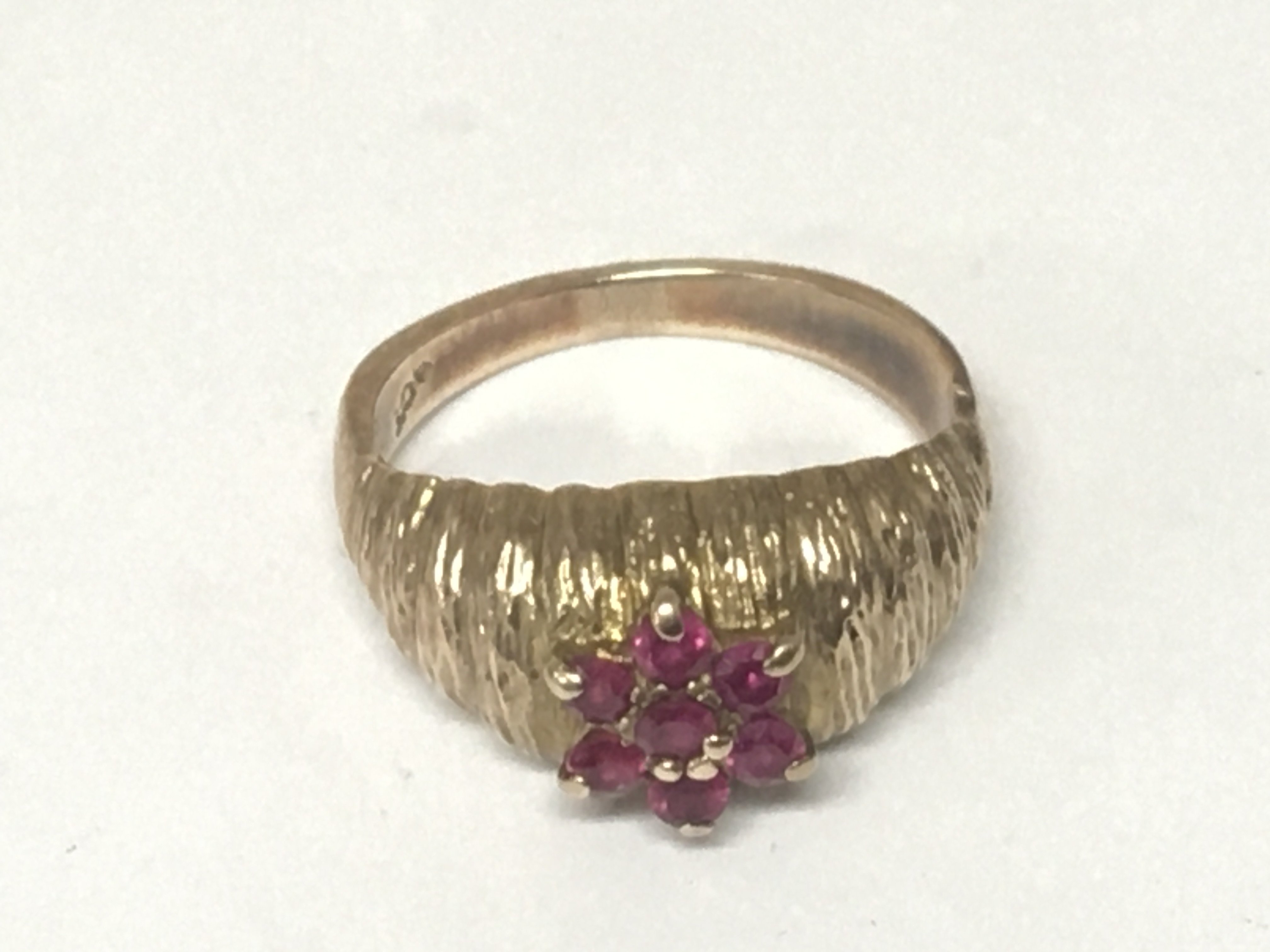 A 9carat gold ring set with a pattern of ruby. ring size O weight 4g