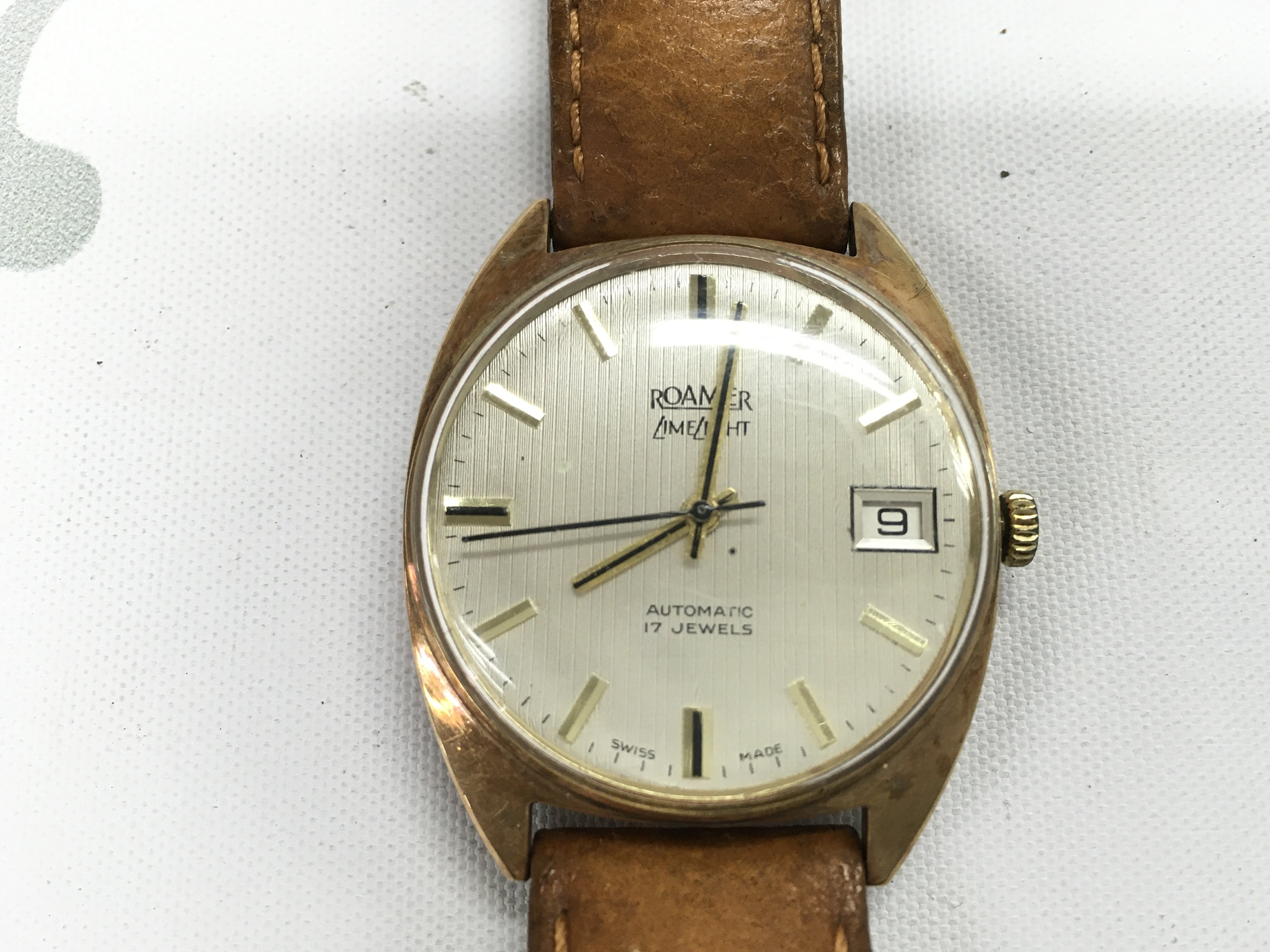 A vintage 9ct cased Roamer on a leather strap with box and tag. Postage B