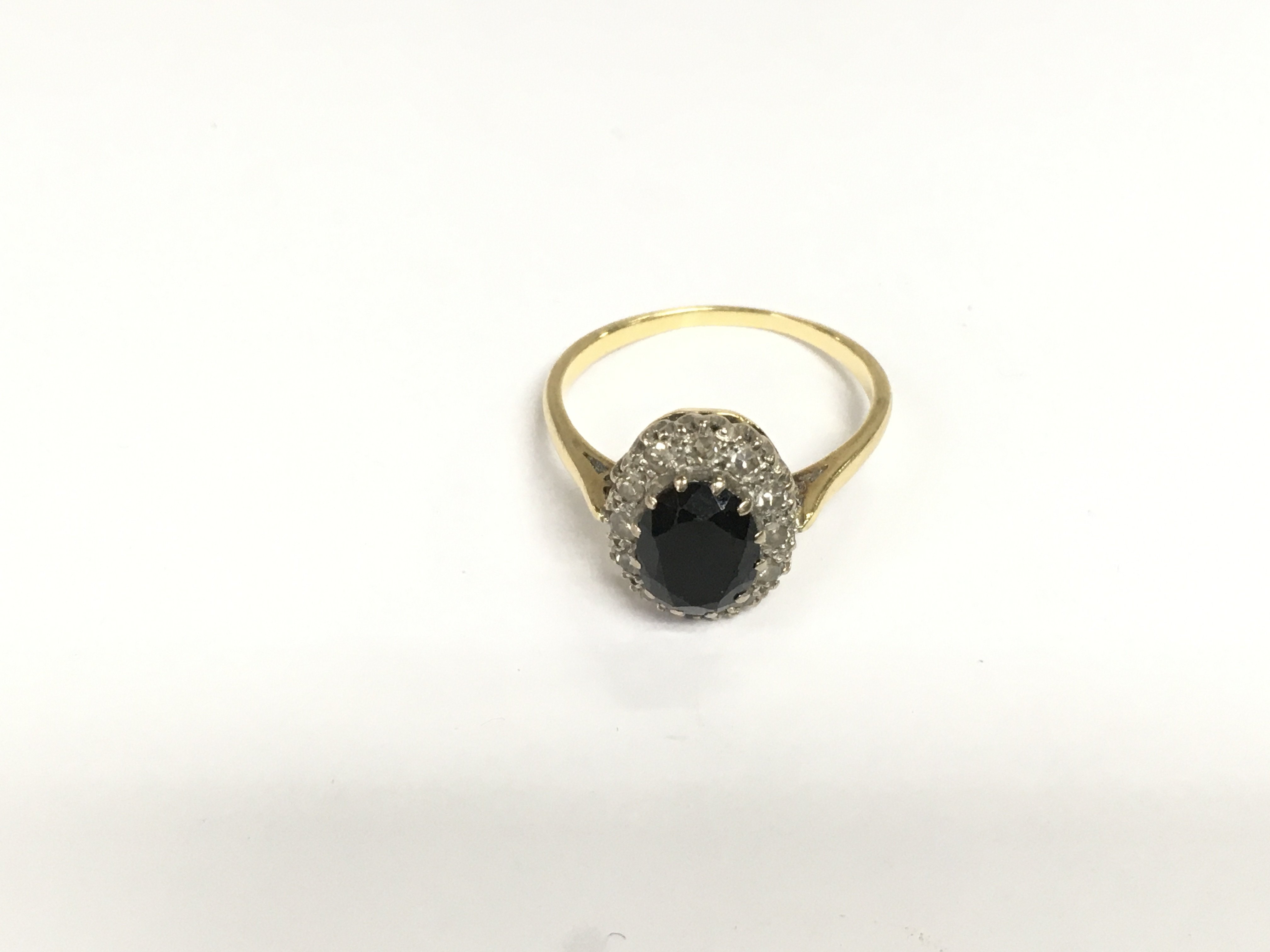 A gold ring set with a central sapphire surrounded by diamonds, approx 3.8g and approx size Q. Shipping category A.