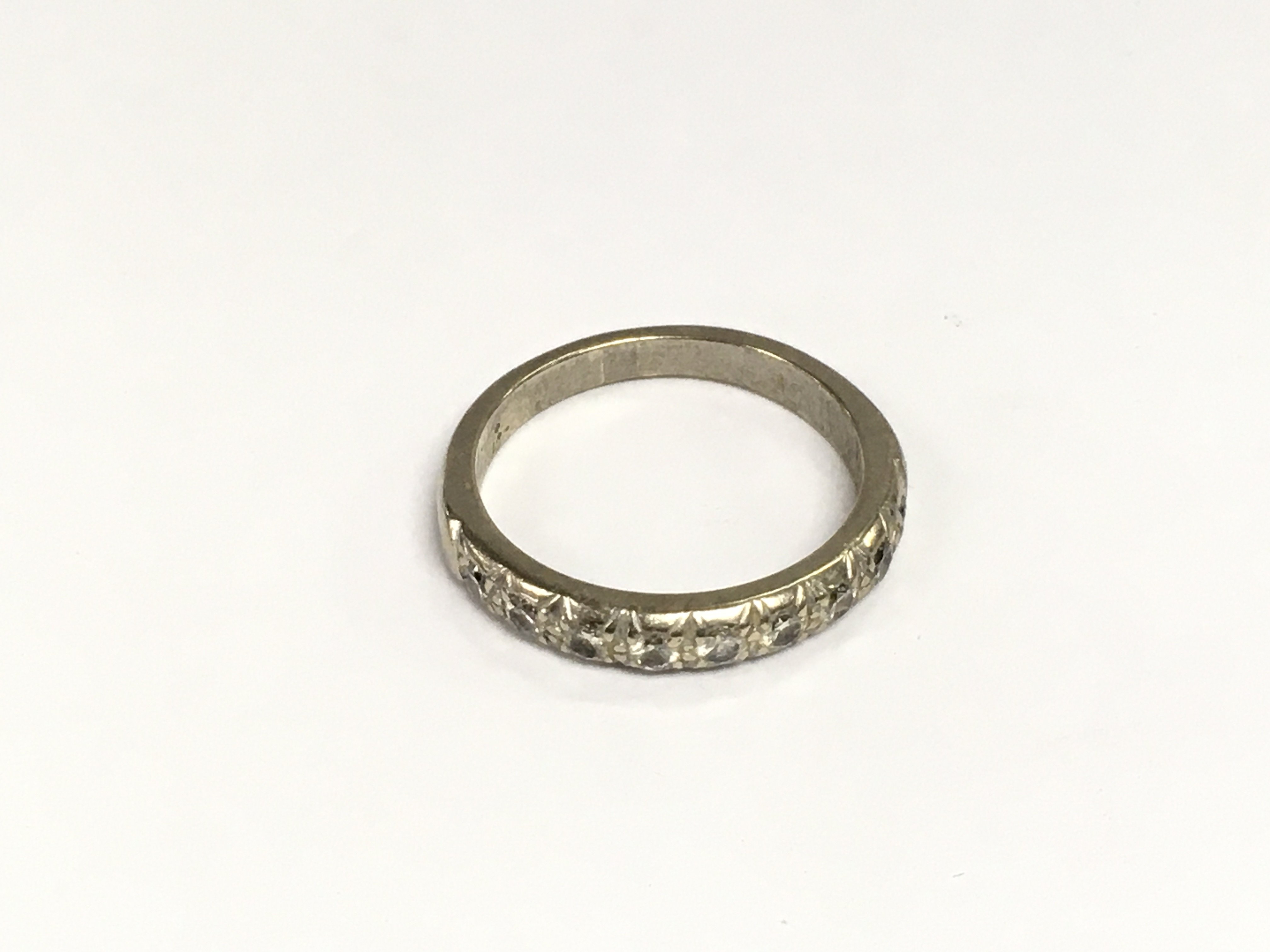 An 18ct white gold half hoop eternity ring, approx 4.9g and approx size P. Shipping category A.