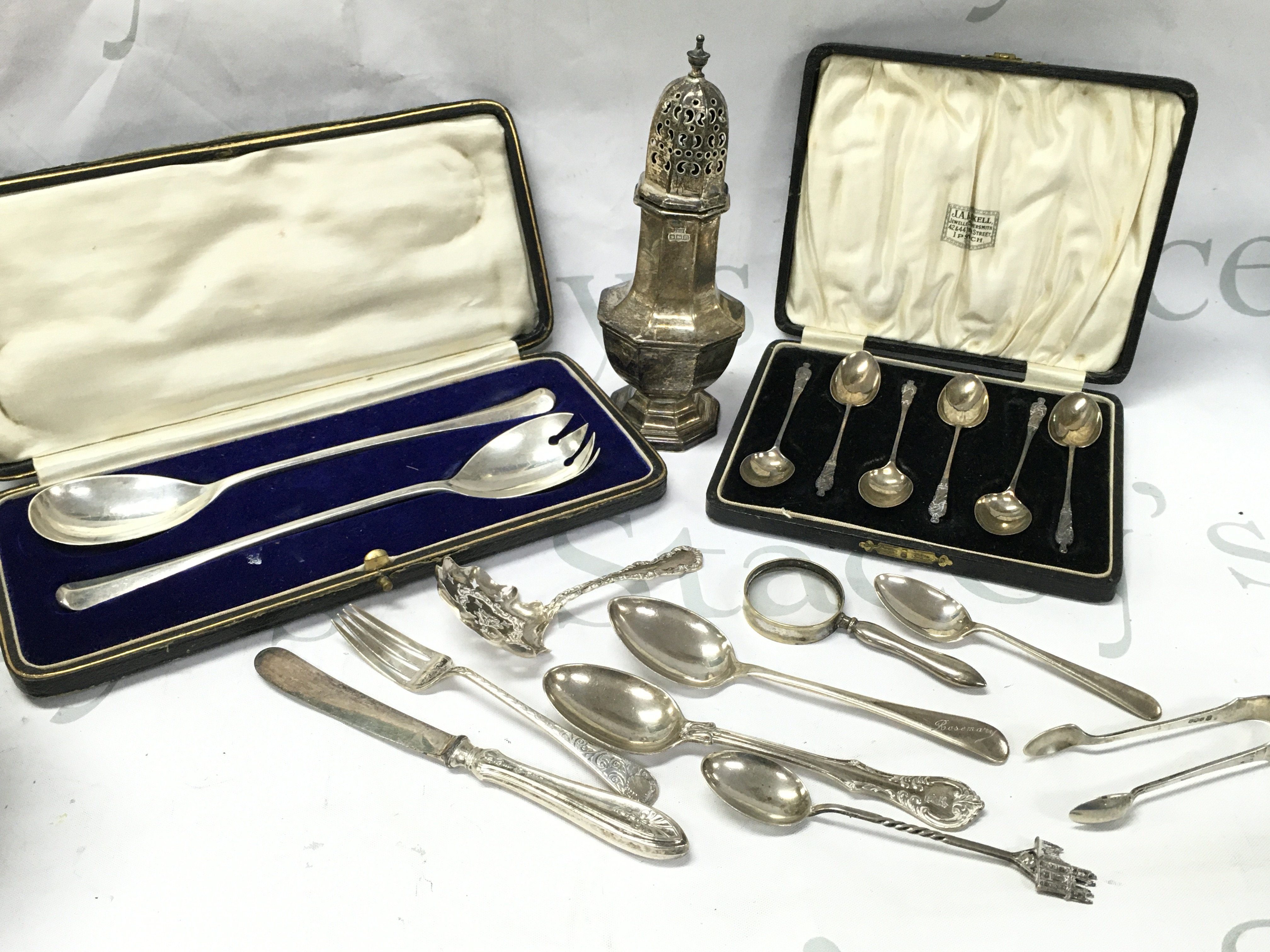 Silver hallmarked items including a Sugar sifter, Cased coffee spoons , Cased salad servers, magnifying glass etc . Postage cat b