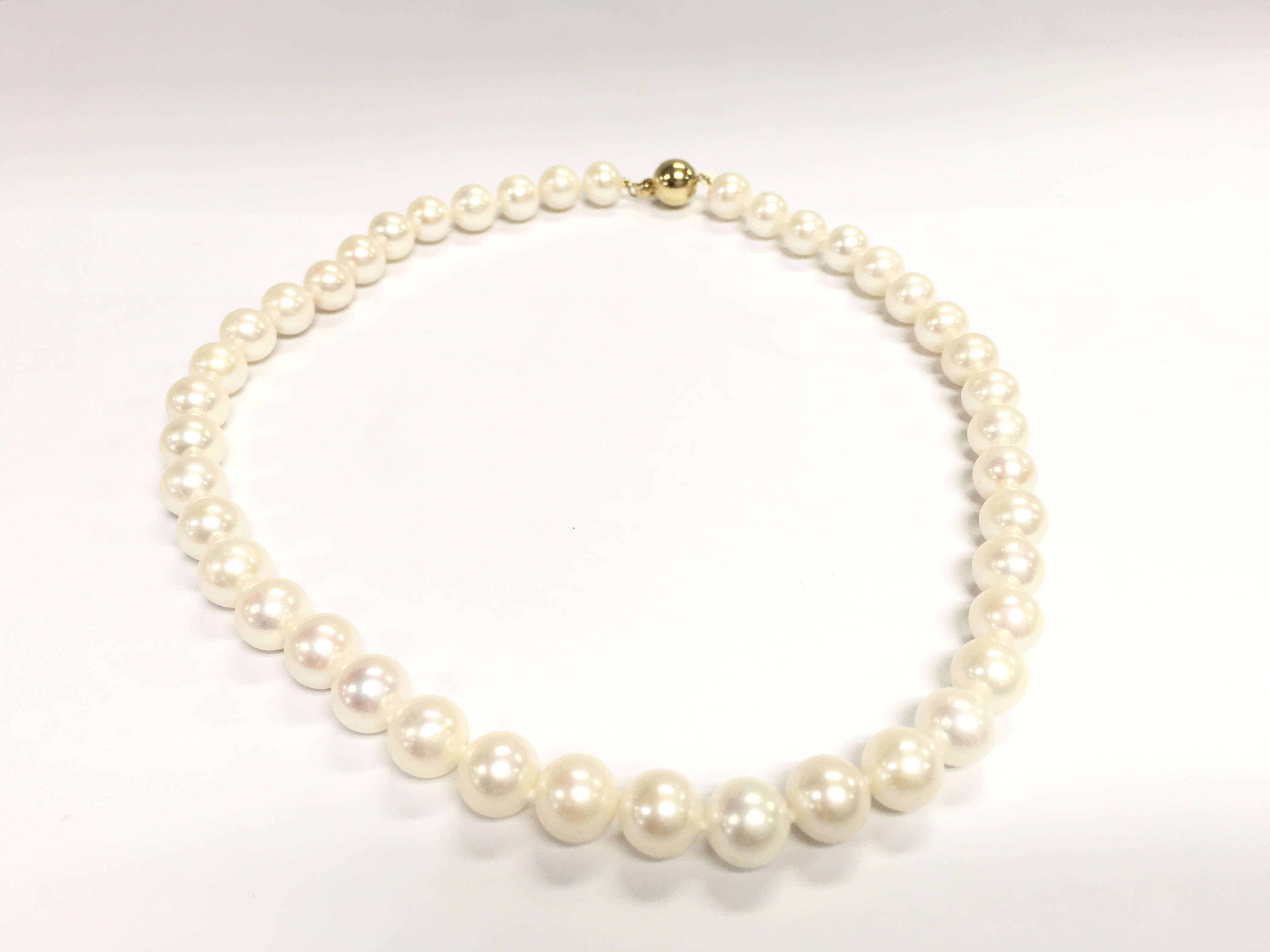An 18inch string of white pearls with a 9ct yellow gold ball clasp. Postage B