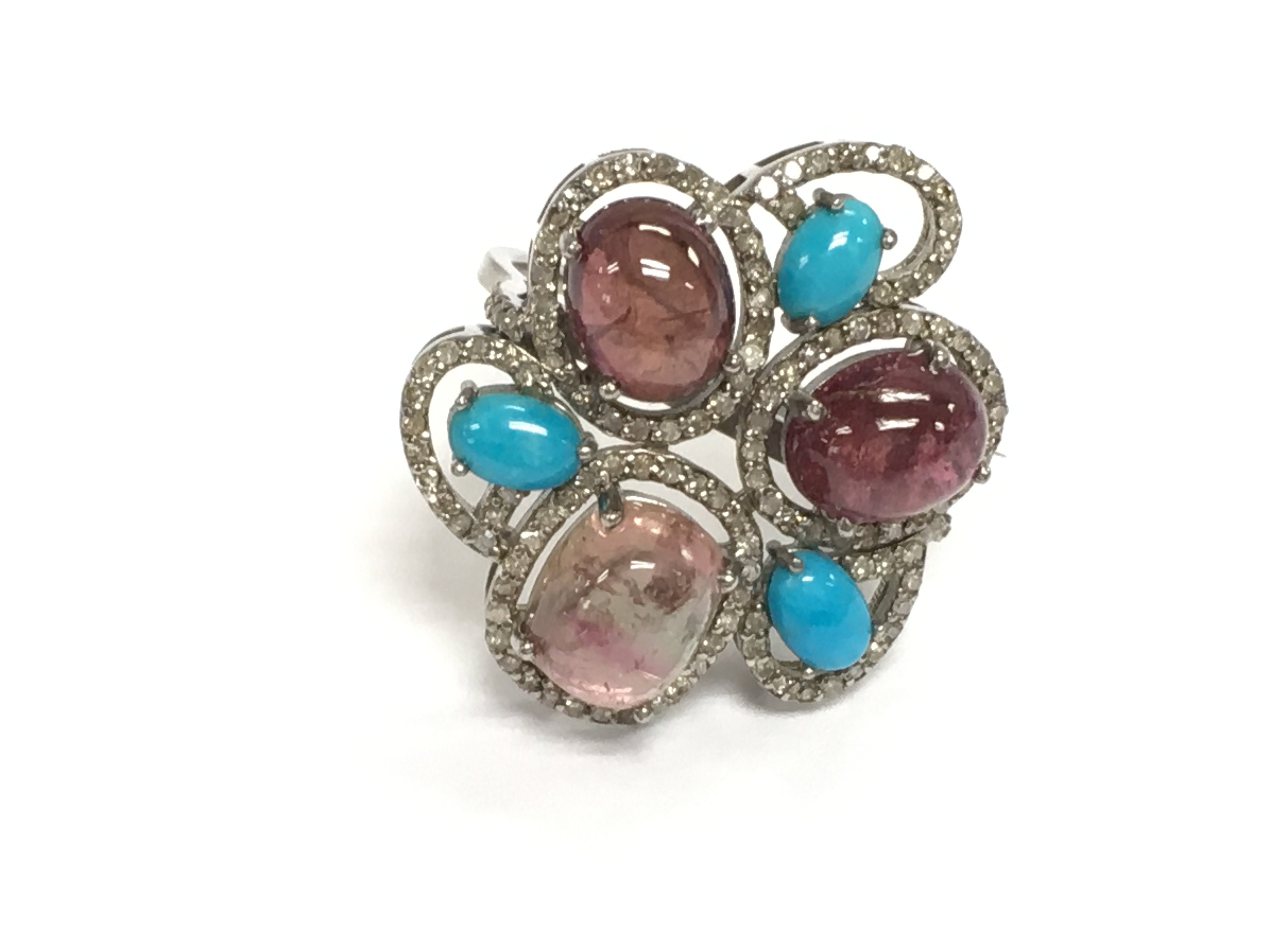 A silver large floral style dress ring with cabochon turquoise and pink and purple tourmalines and diamonds. Turquoise 1.15ct tourmaline 11.74ct and diamonds 0.78ct all approximate. Size P