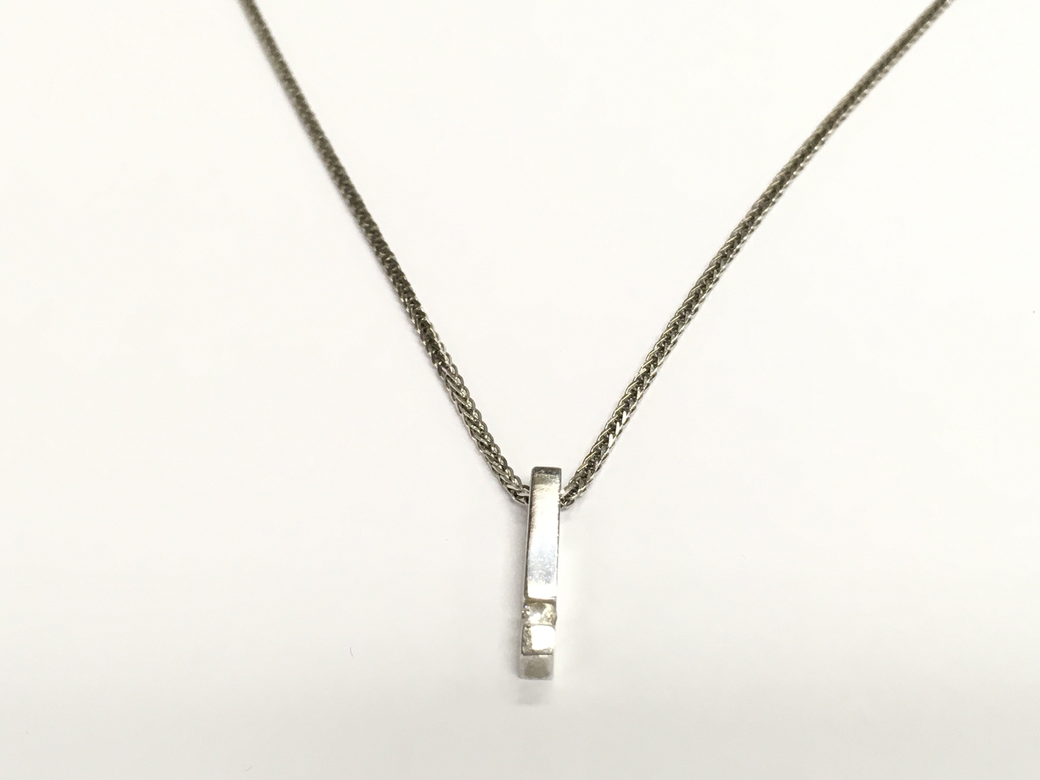 A 9ct white gold chain and 9ct gold pendant inset with small diamond. 2.76g