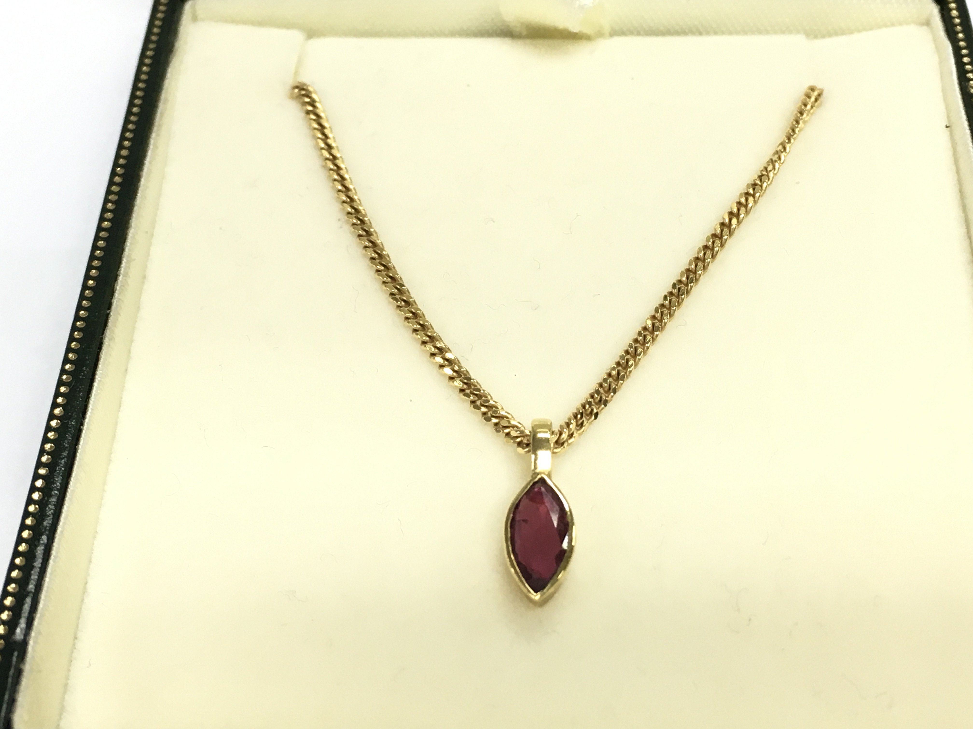A 9ct gold chain with ruby pendant. 4.82g