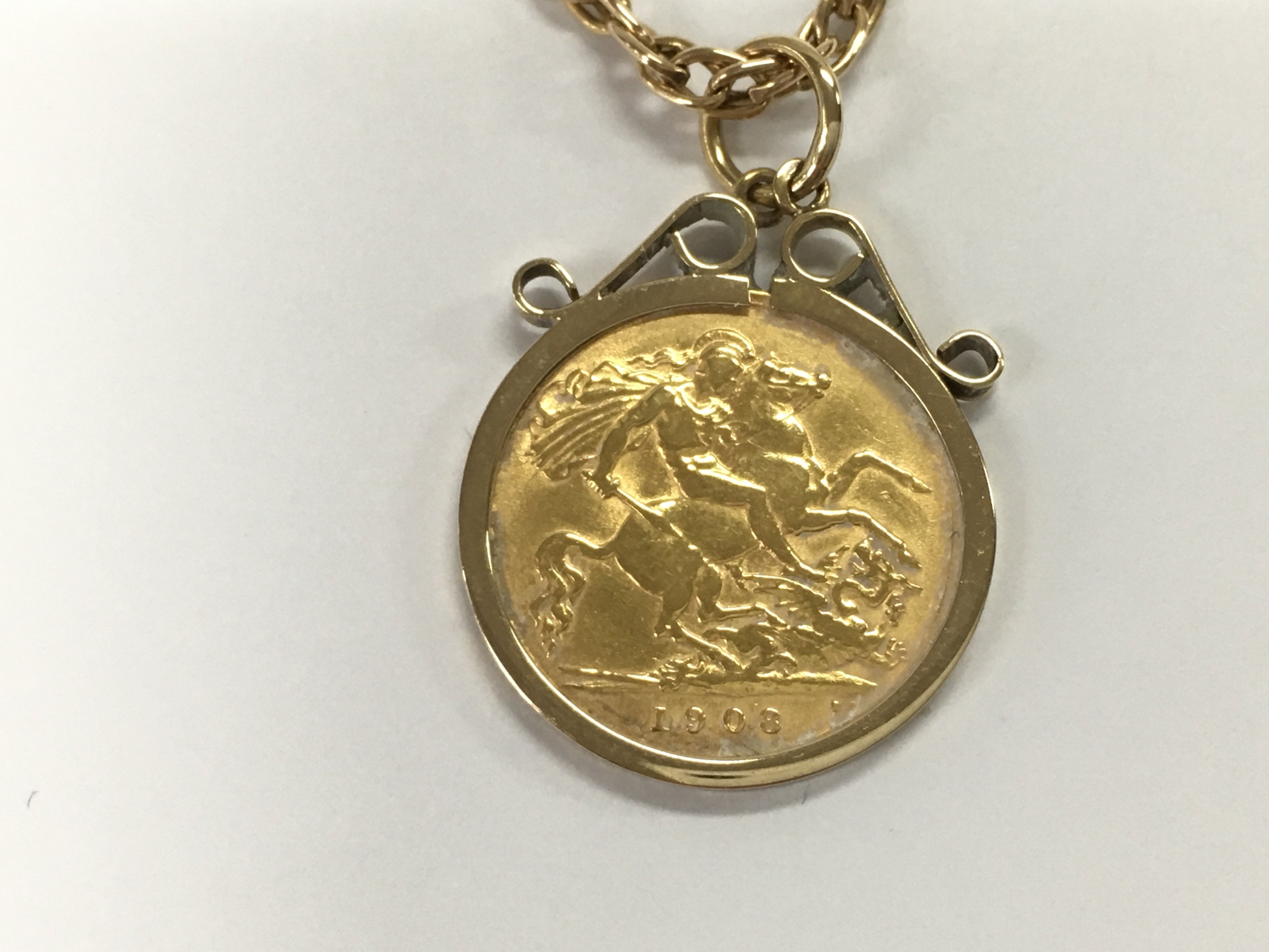A 1908 1/2 sovereign in 9ct gold mount and chain. 15.50g