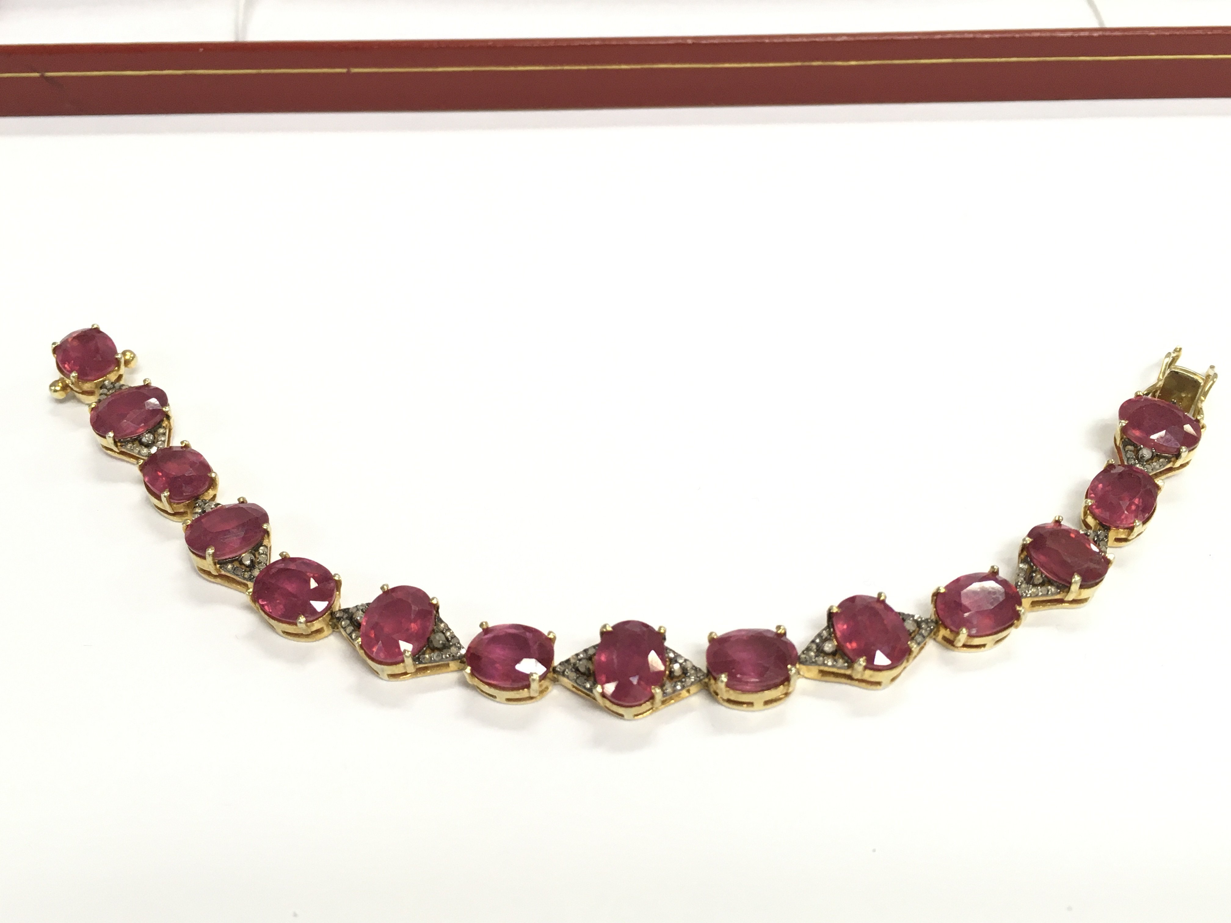 Silver gilt bracelet set with oval rubies (glass filled) and diamonds. Rubies Approx 28ct and 0.70ct diamonds.