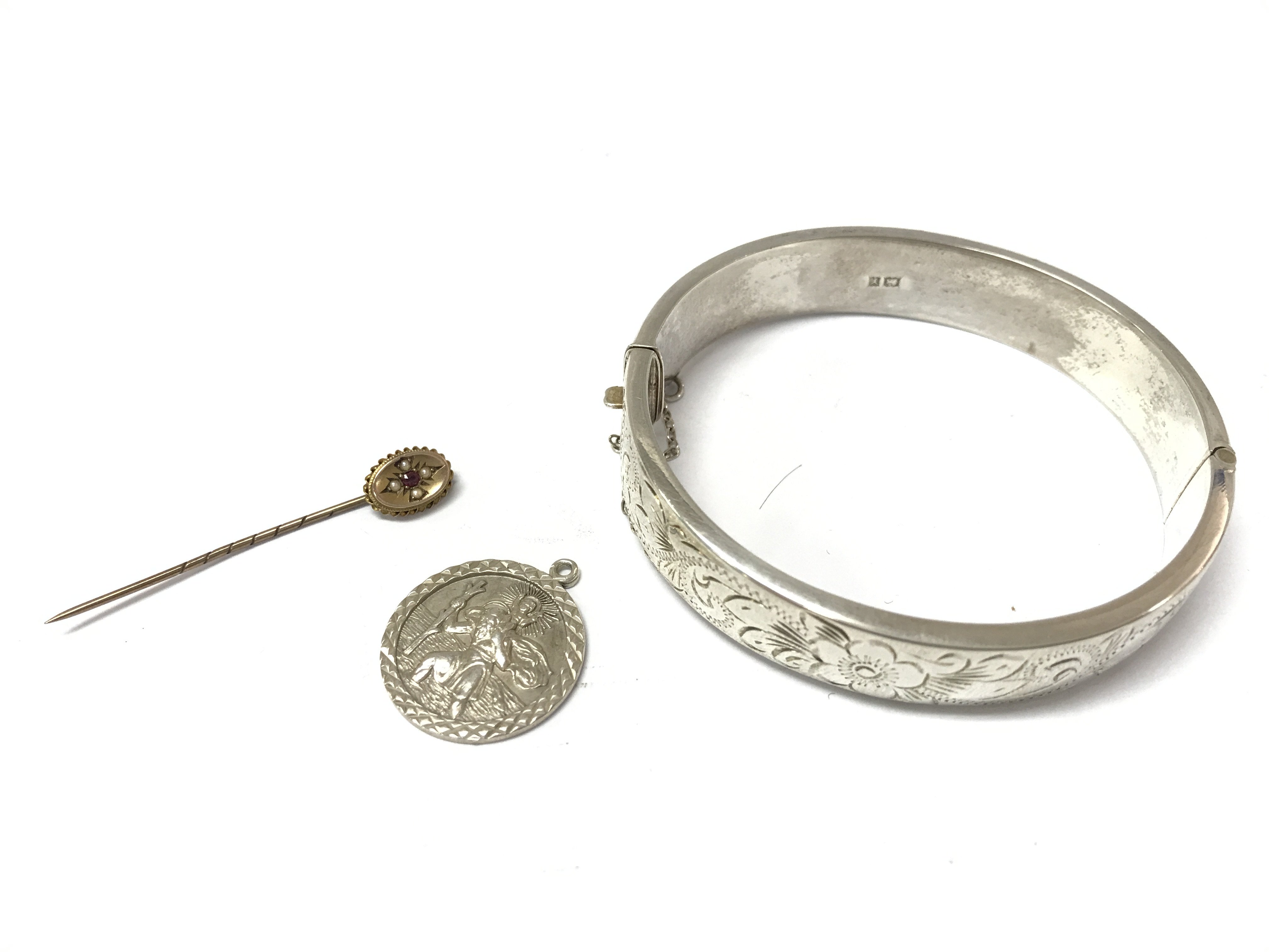 A silver bangle, silver locket, a silver st Christopher pendant and a 9ct gold stick pin. Postage cat a