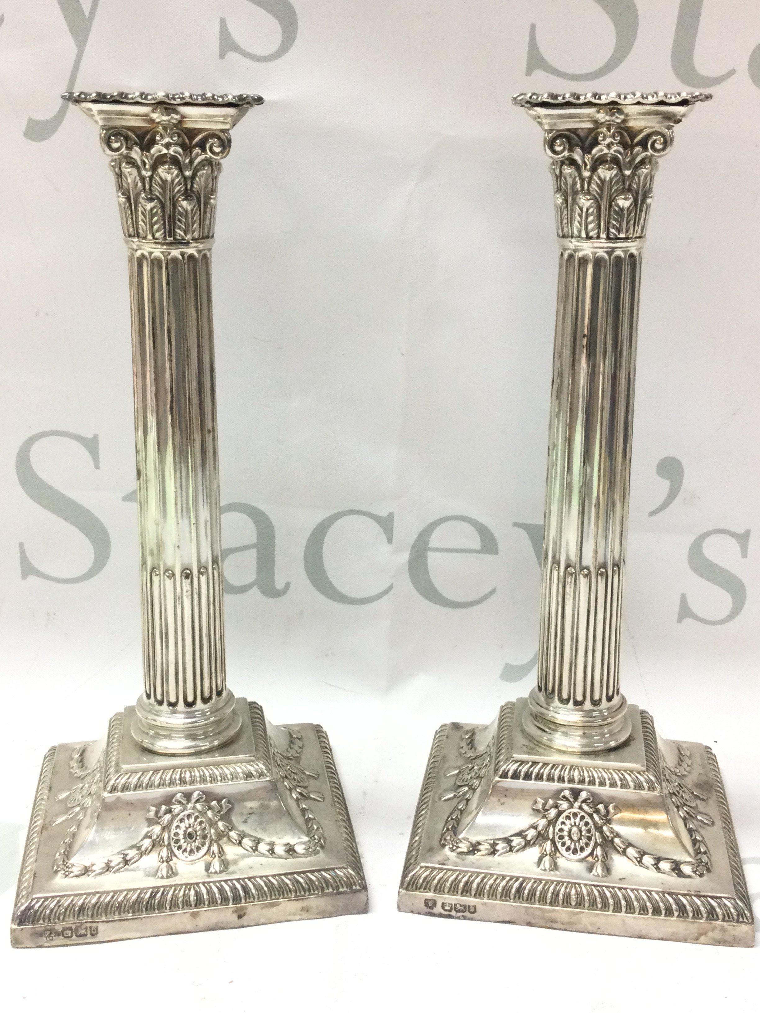 A pair of silver hallmarked corinthian column Candlesticks ,23cm tall.postage category B