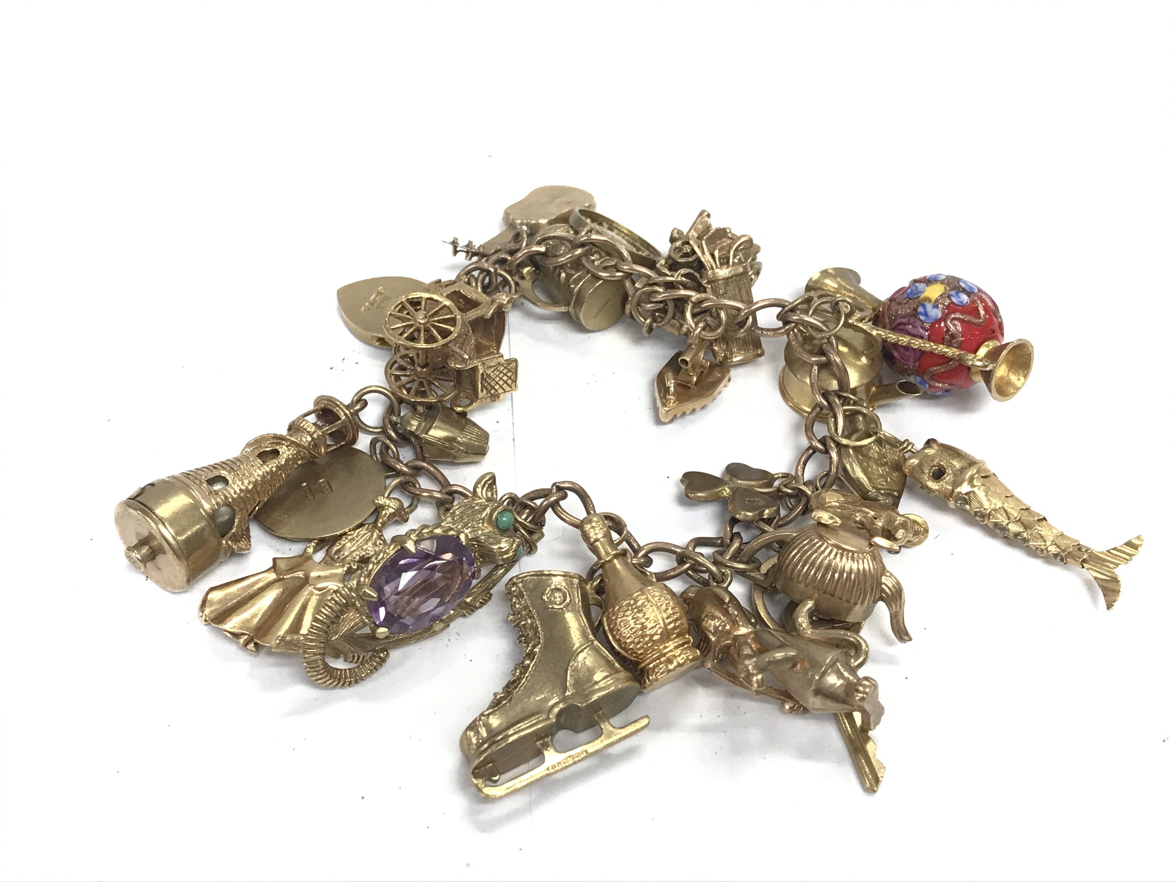 A 9ct charm bracelet with a large number of charms. 82.05g Postage B