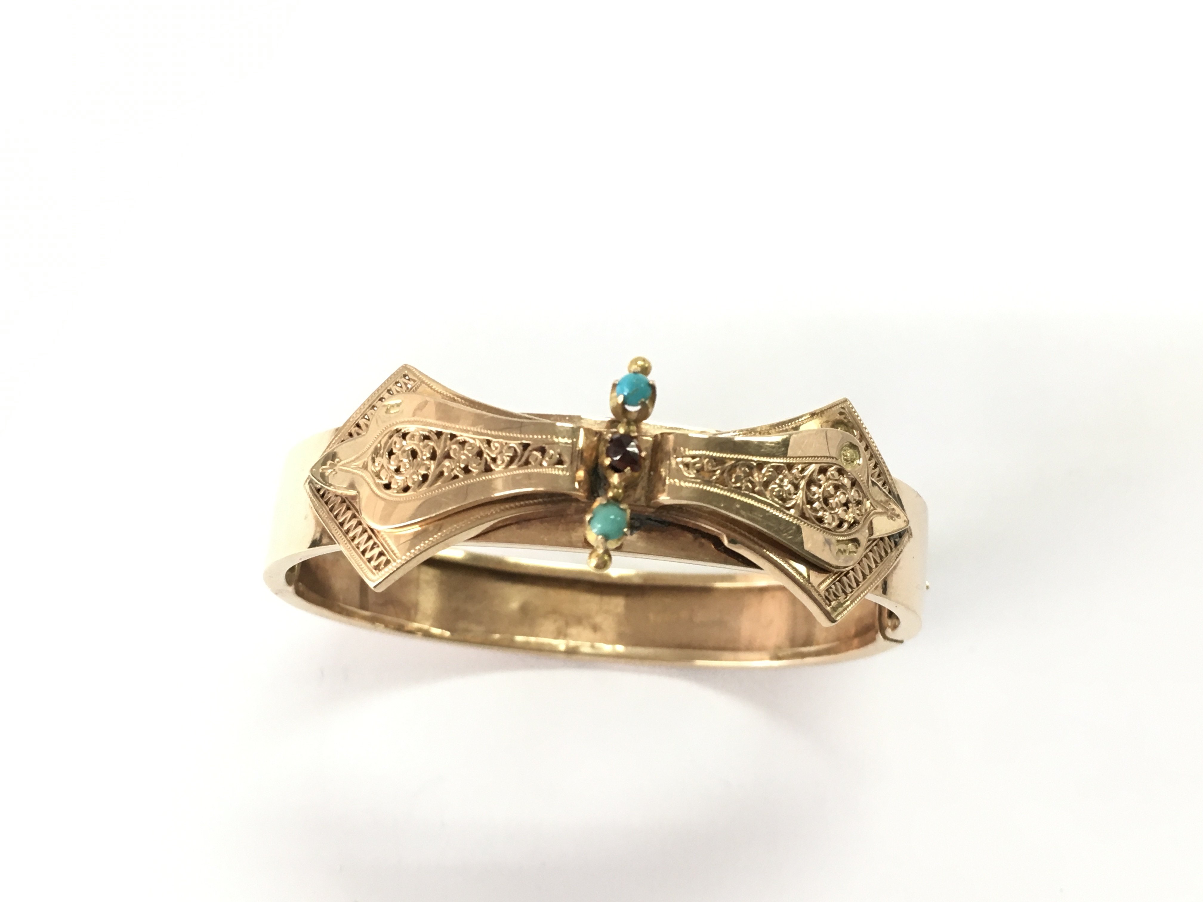 A 15ct Russian gold bangle set with garnet and turquoise. 15.39g and 6cm diameter. Postage A