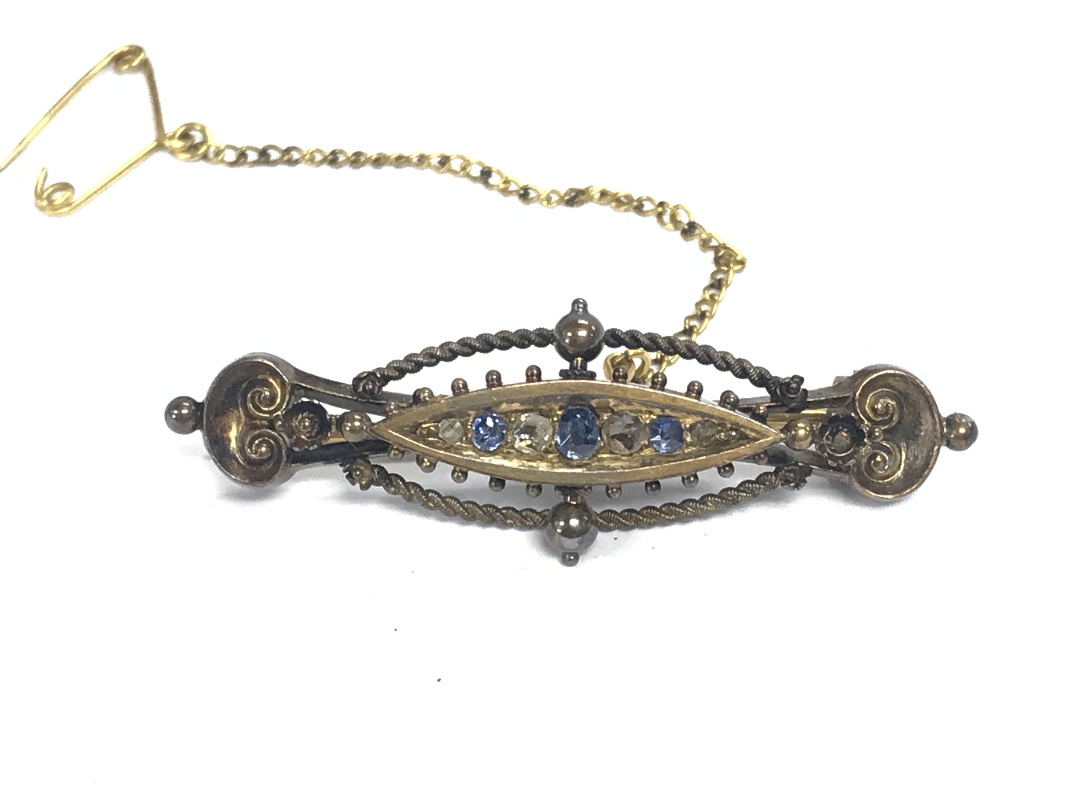 A 15ct gold brooch set with small sapphires. Has Chester hallmarks. Approximately 5cm wide and 5g
