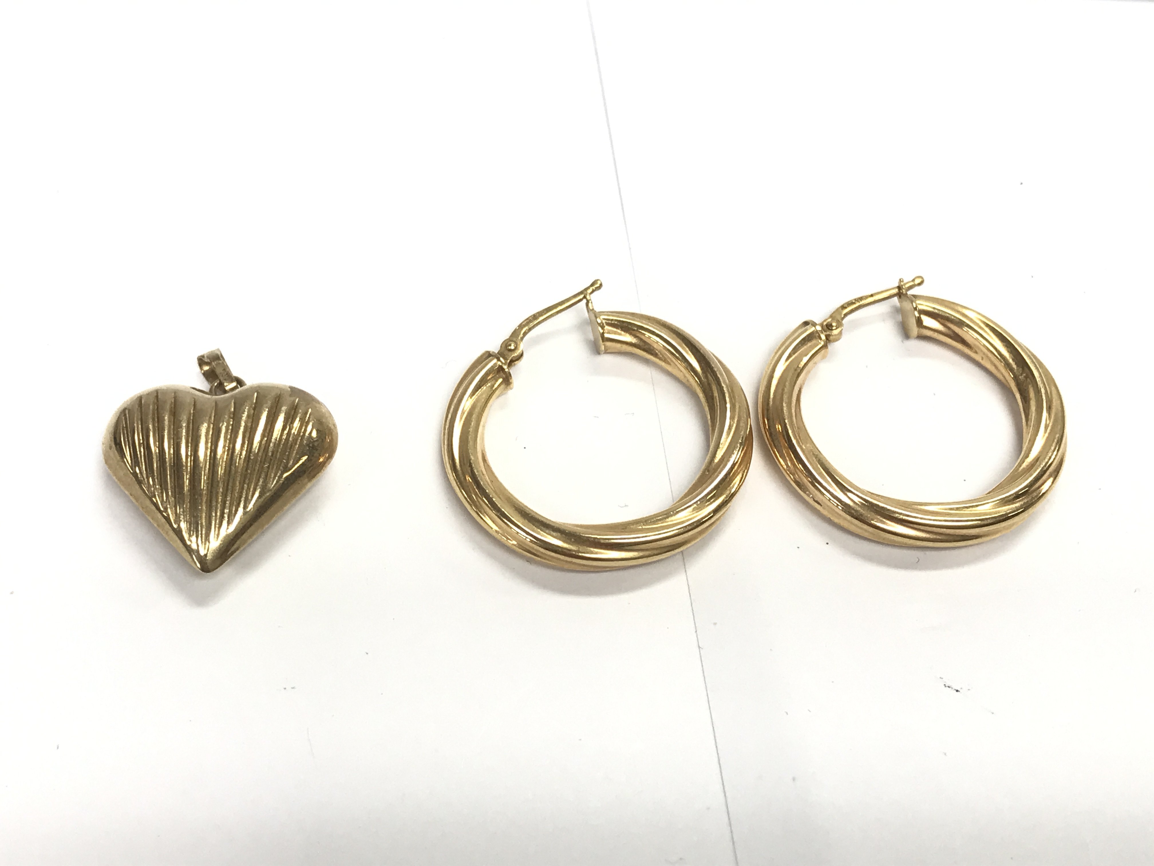 A pair of 9ct gold hoop earrings and a 9ct gold heart pendant. 4g Postage A