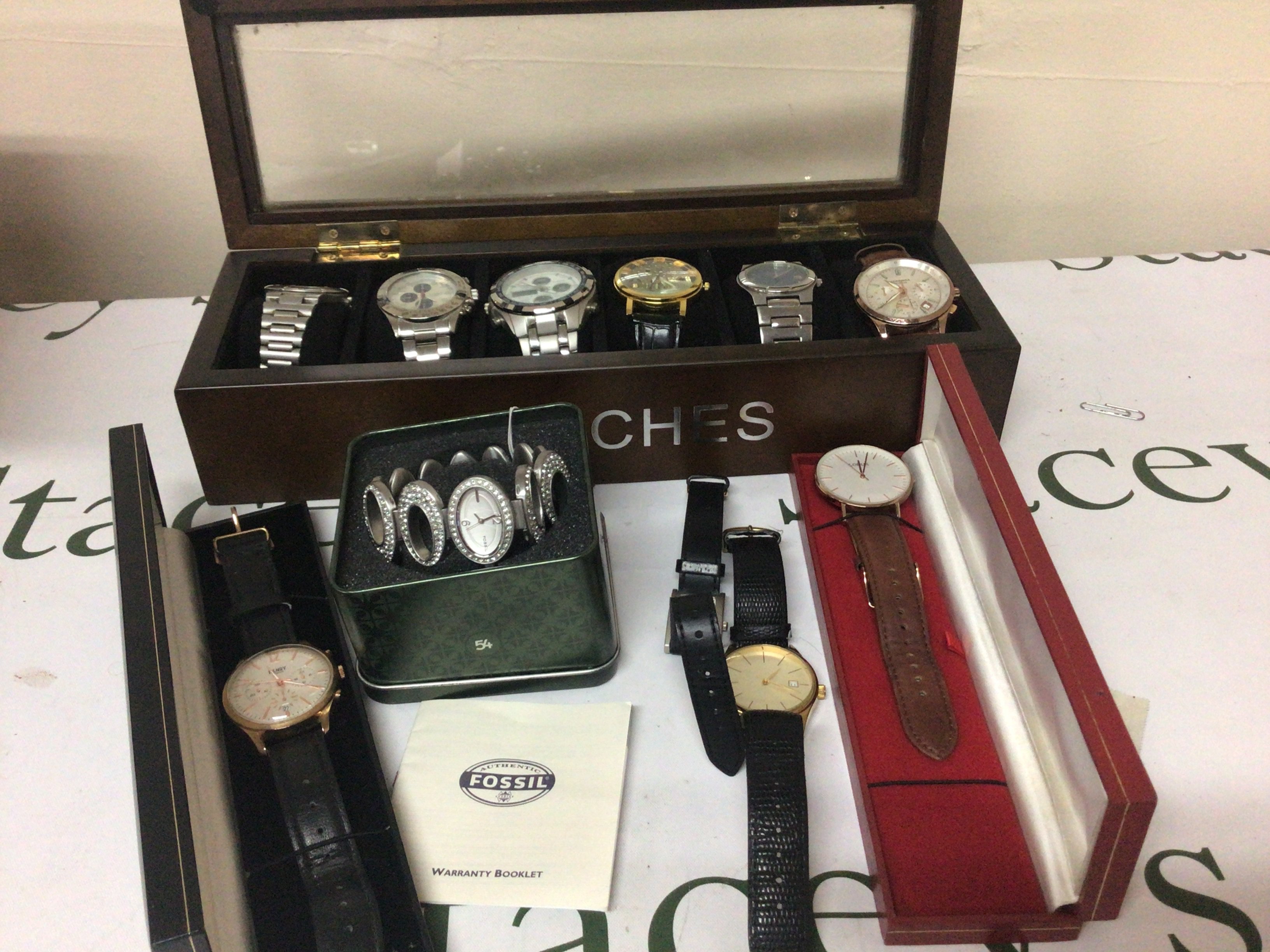 A collection of gents watches including a Henry British design Chronograph watch and other watches in a watch box.