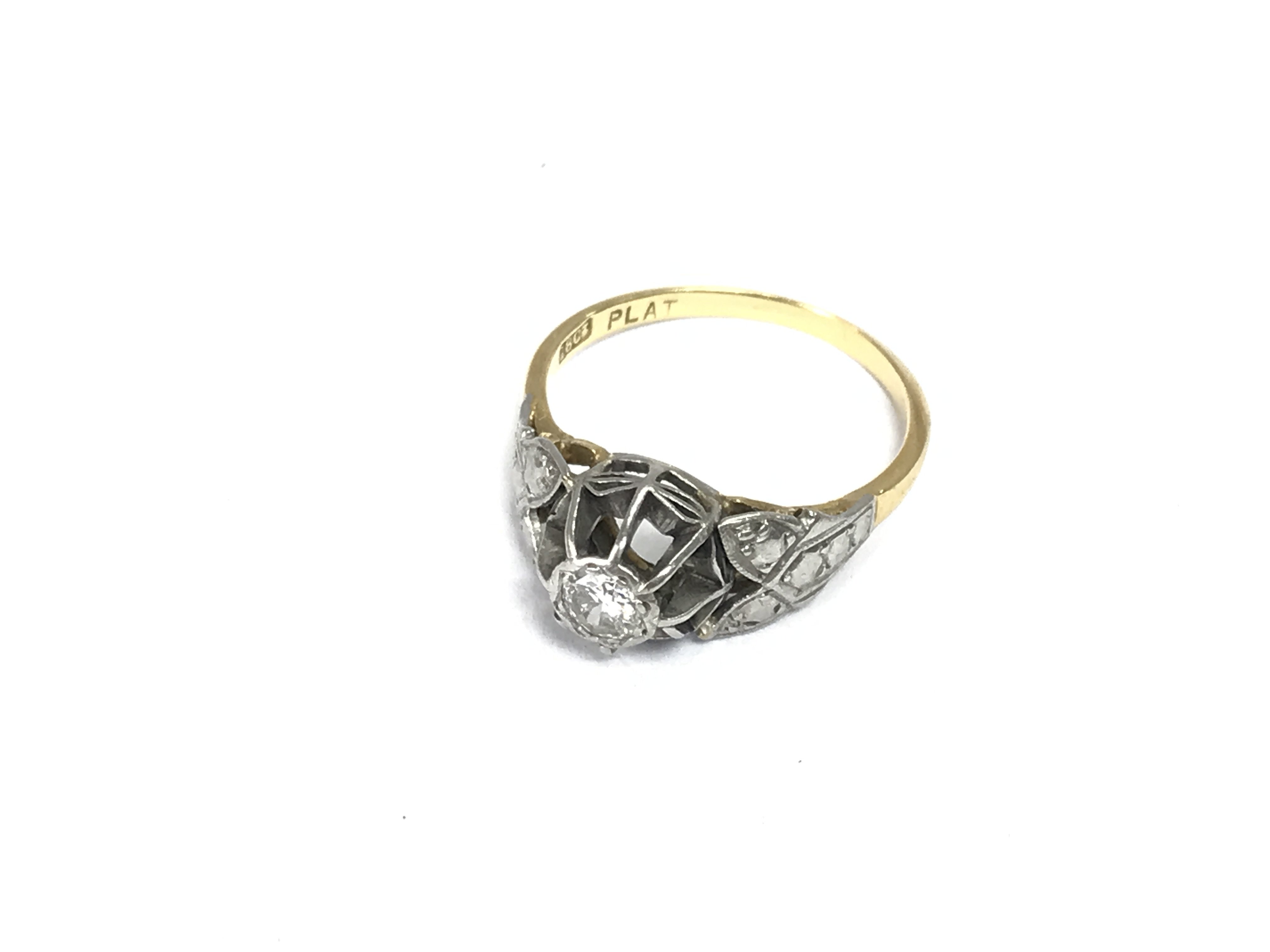 An 18ct gold and platinum diamond solitaire ring. Approximately size O and 3.36g