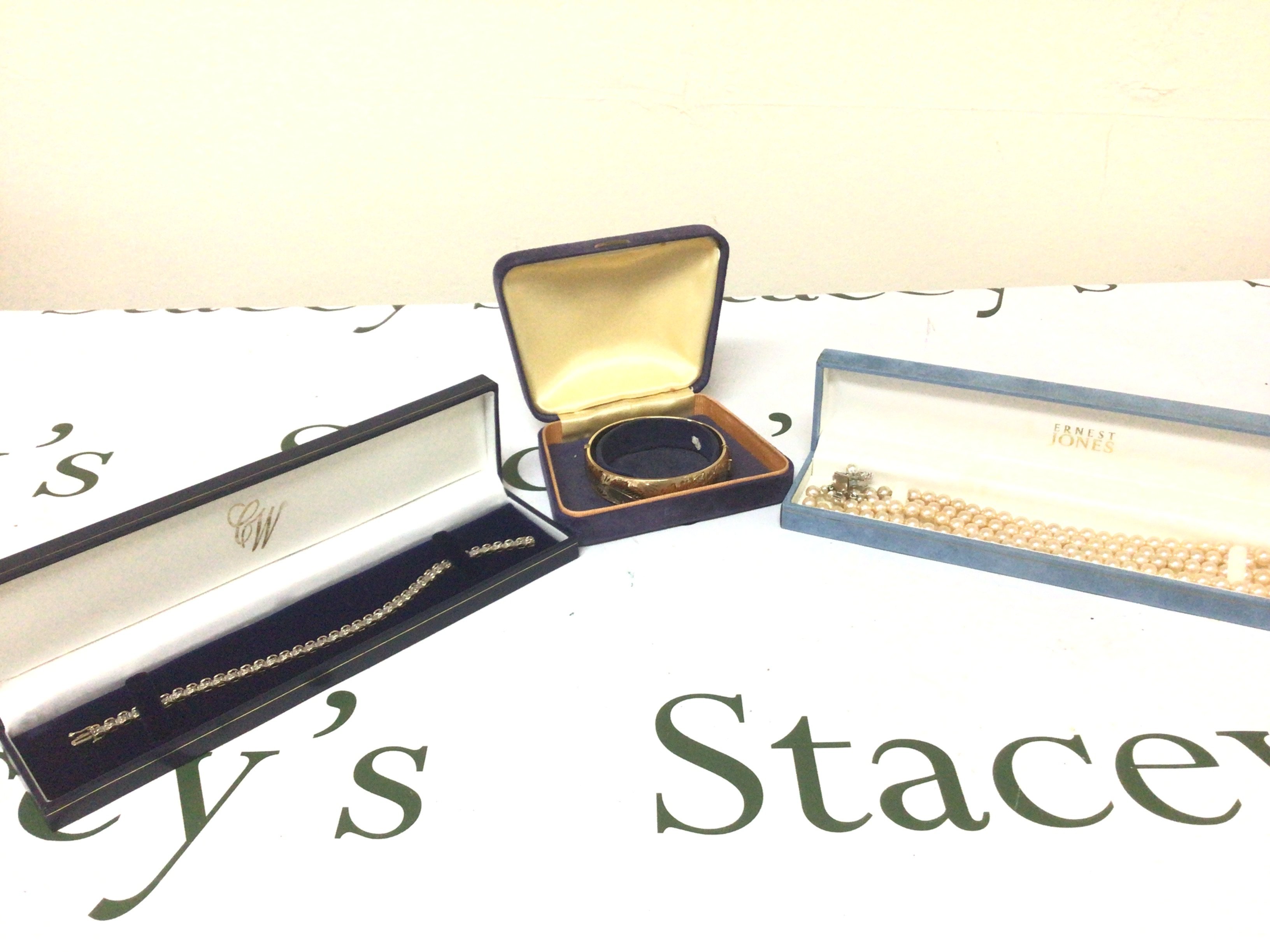 A 9carat gold bracelet weight 7g and a gold 1/5 bangle and a boxed simulated pearl necklace.