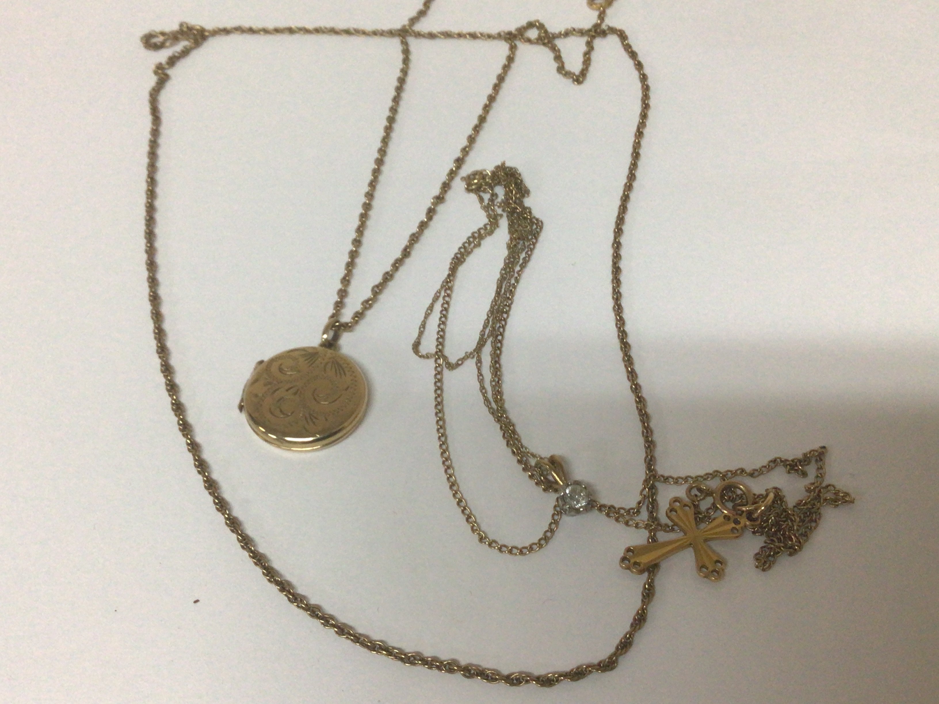 Four 9carat gold chains with an attached gold locket cross pendent and one ther and one gold chain. Weight 13g (4)