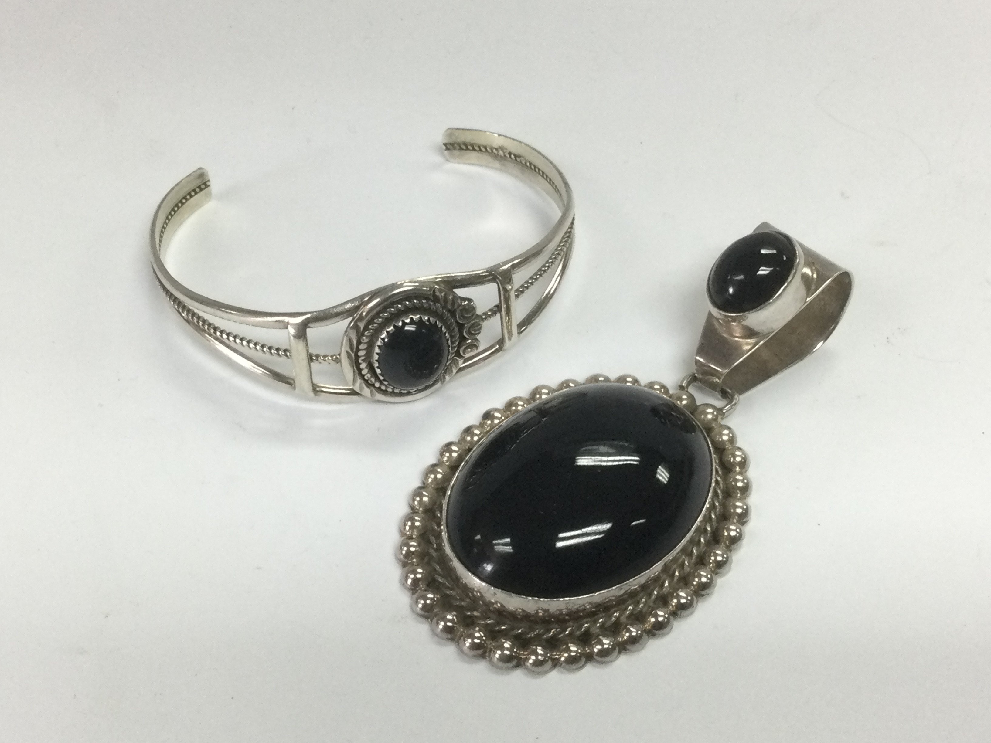 A large silver pendant set with black stones plus a silver bangle set with a central black stone (2). Shipping category A.