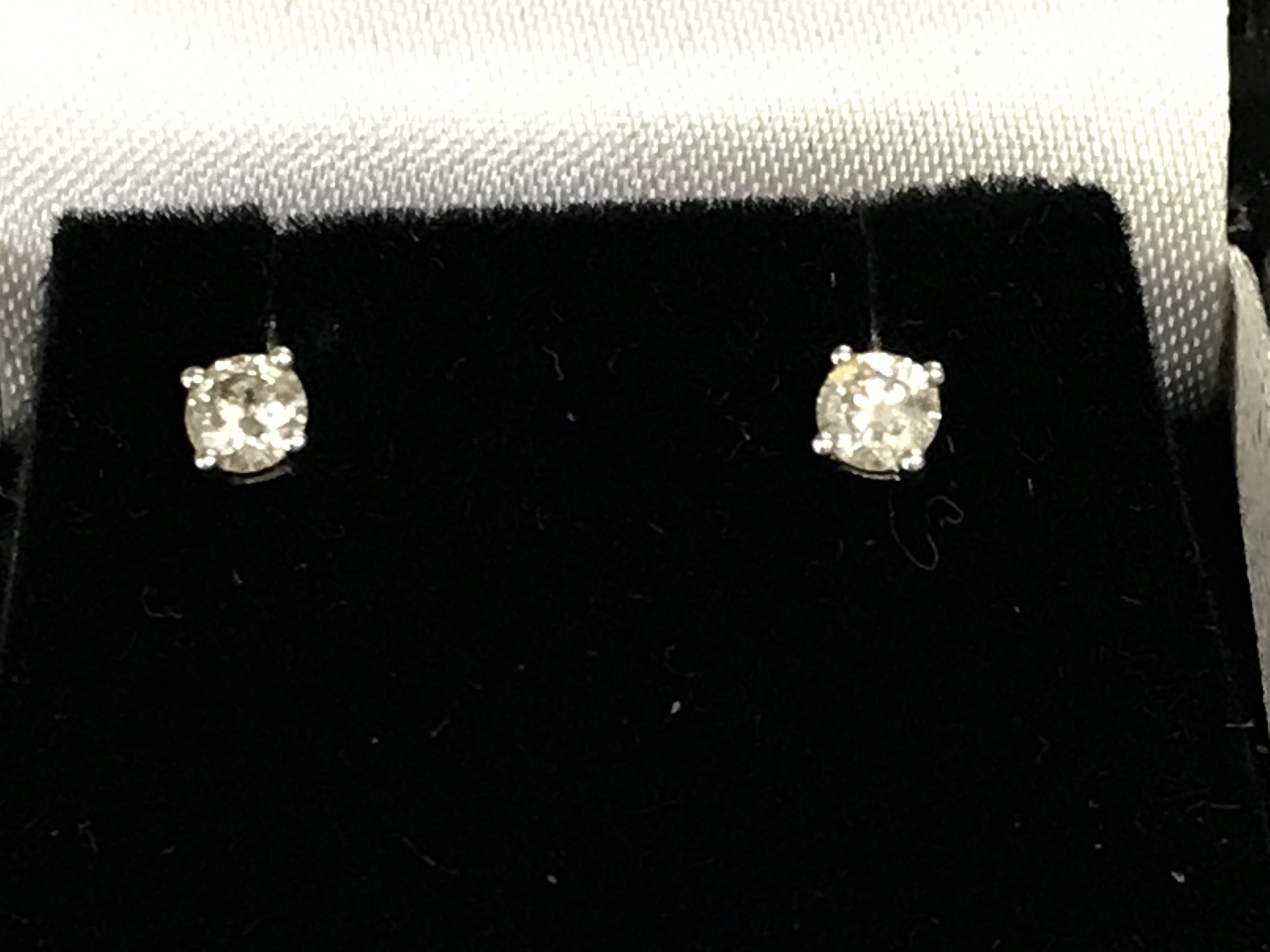 A pair of 9ct white gold diamond studs approximately 0.33ct. Postage A
