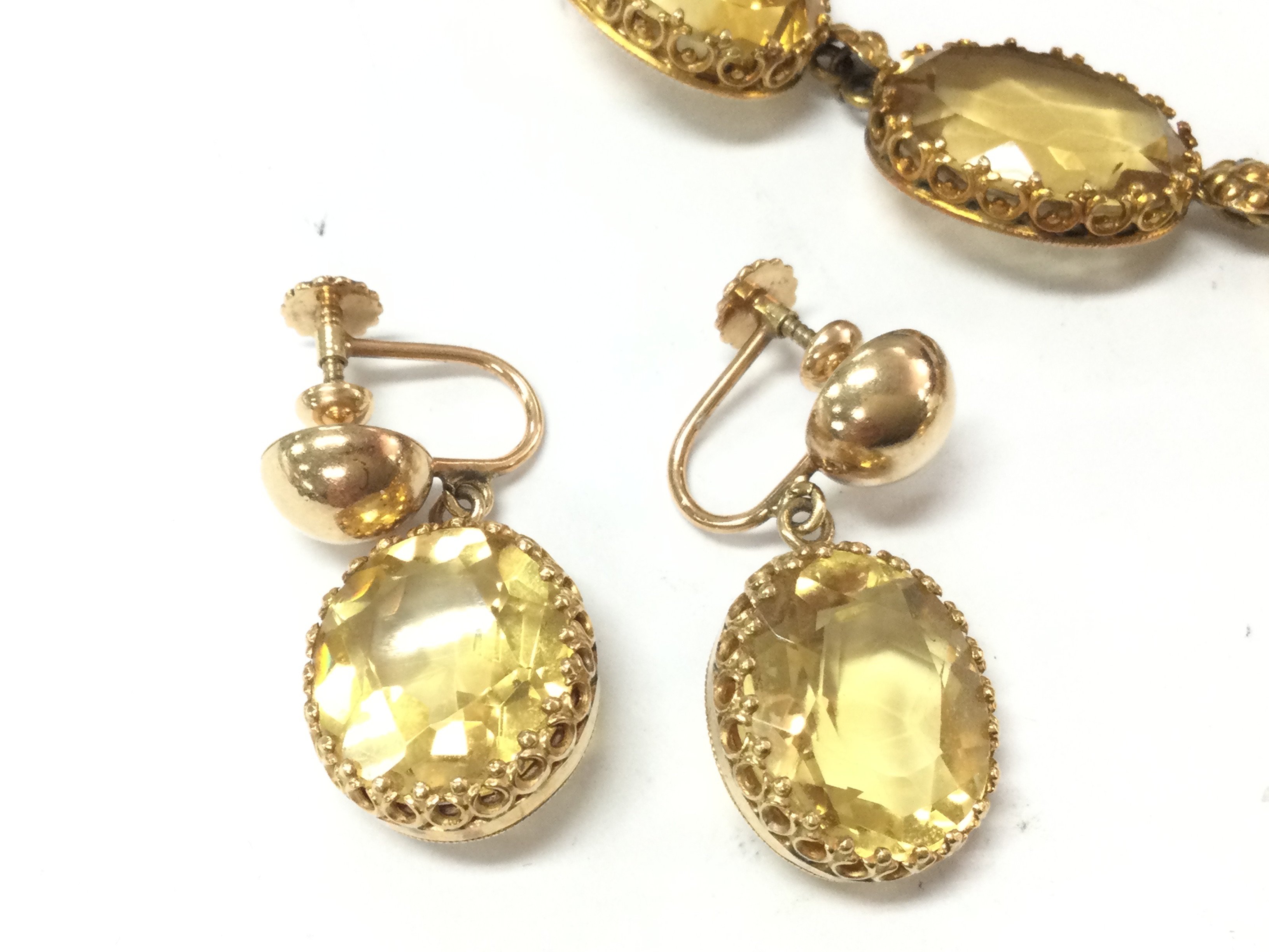 A 14ct gold citrine necklace with 5 oval citrines gold flower links and tear shaped citrine drop. Approx 38cm length and 23.7g with matching 14ct gold oval citrine screw back earrings. 15mm by 12mm and 7.7g Postage B