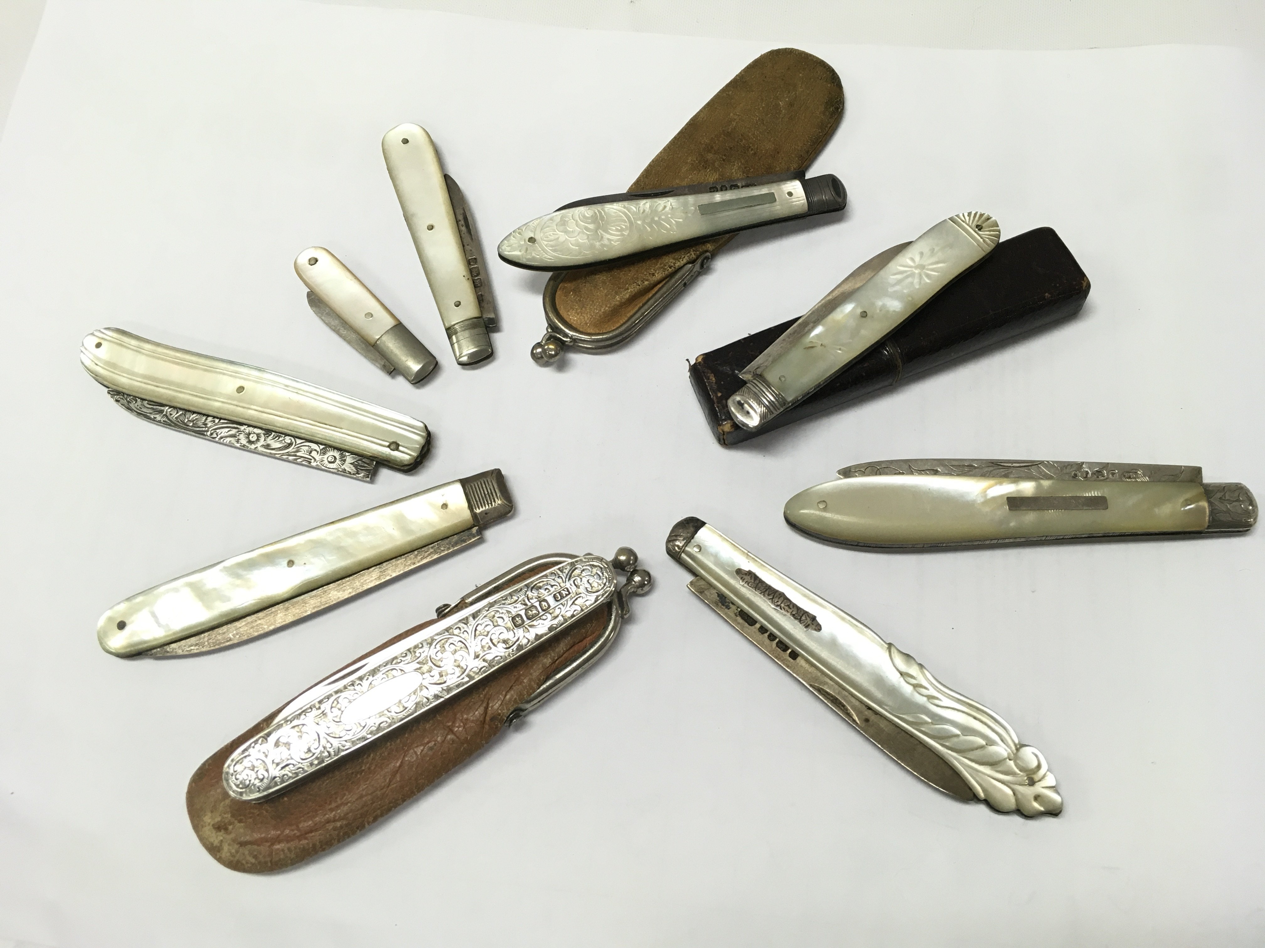 A collection of Mother of Pearl knives and silver hallmarked fruit knives . This lot cannot be posted