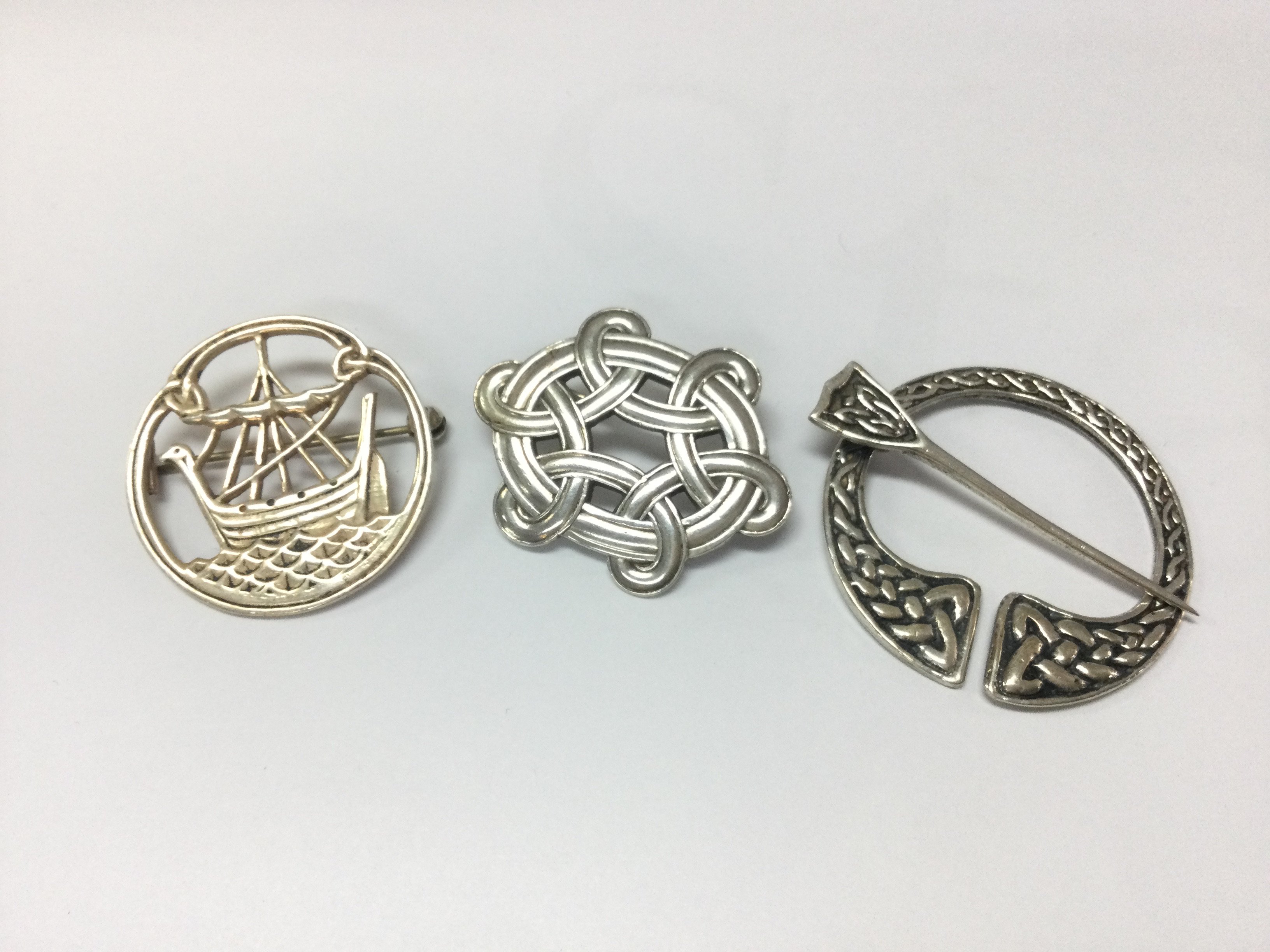 Three sterling silver Celtic brooches . Postage category A