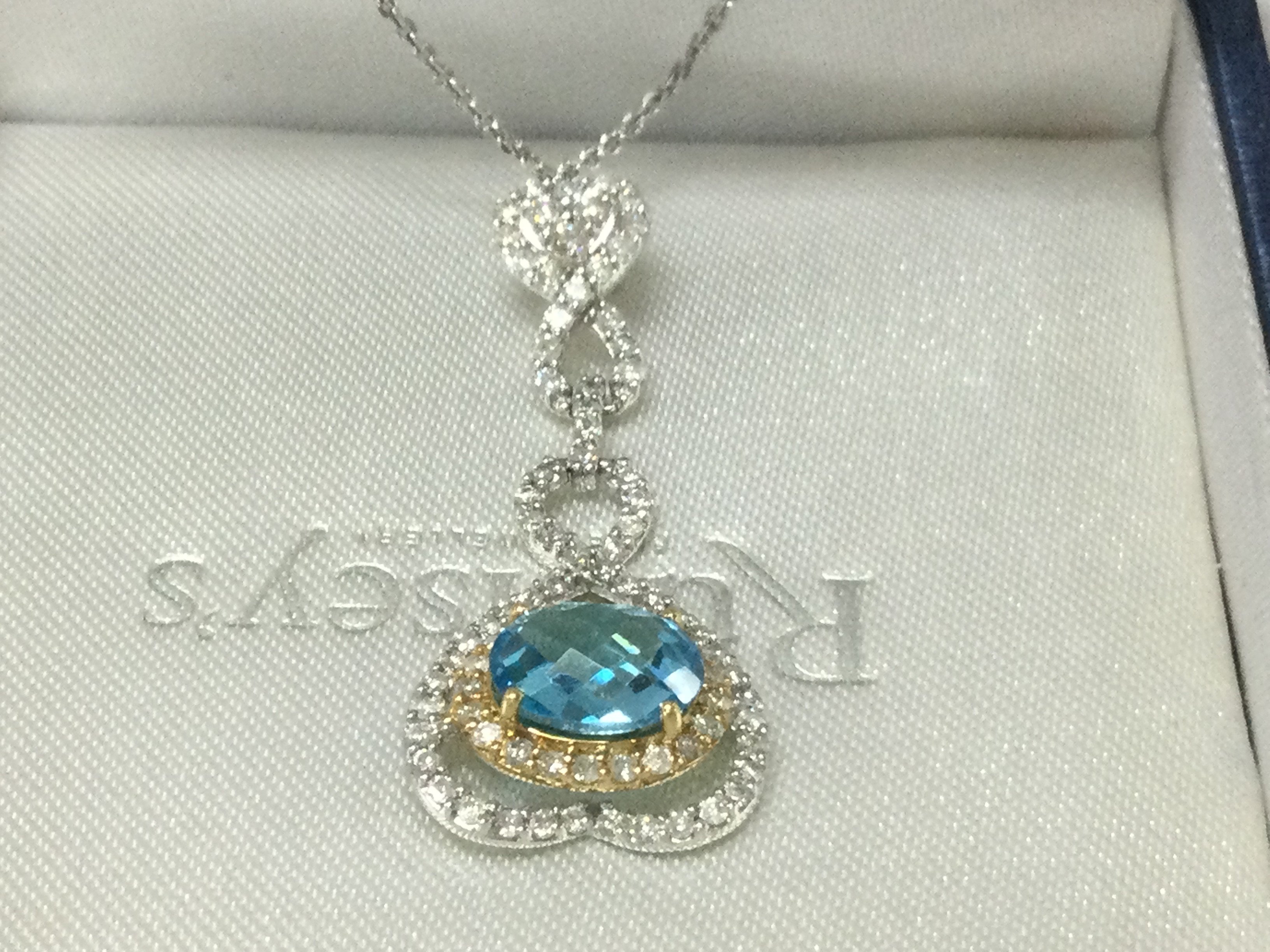 18ct white gold heart pendant set with an oval checkerboard blue topaz and several RBC and R/C diamonds on a silver chain, boxed. Topaz 2.34ct, Diamond 1.00ct