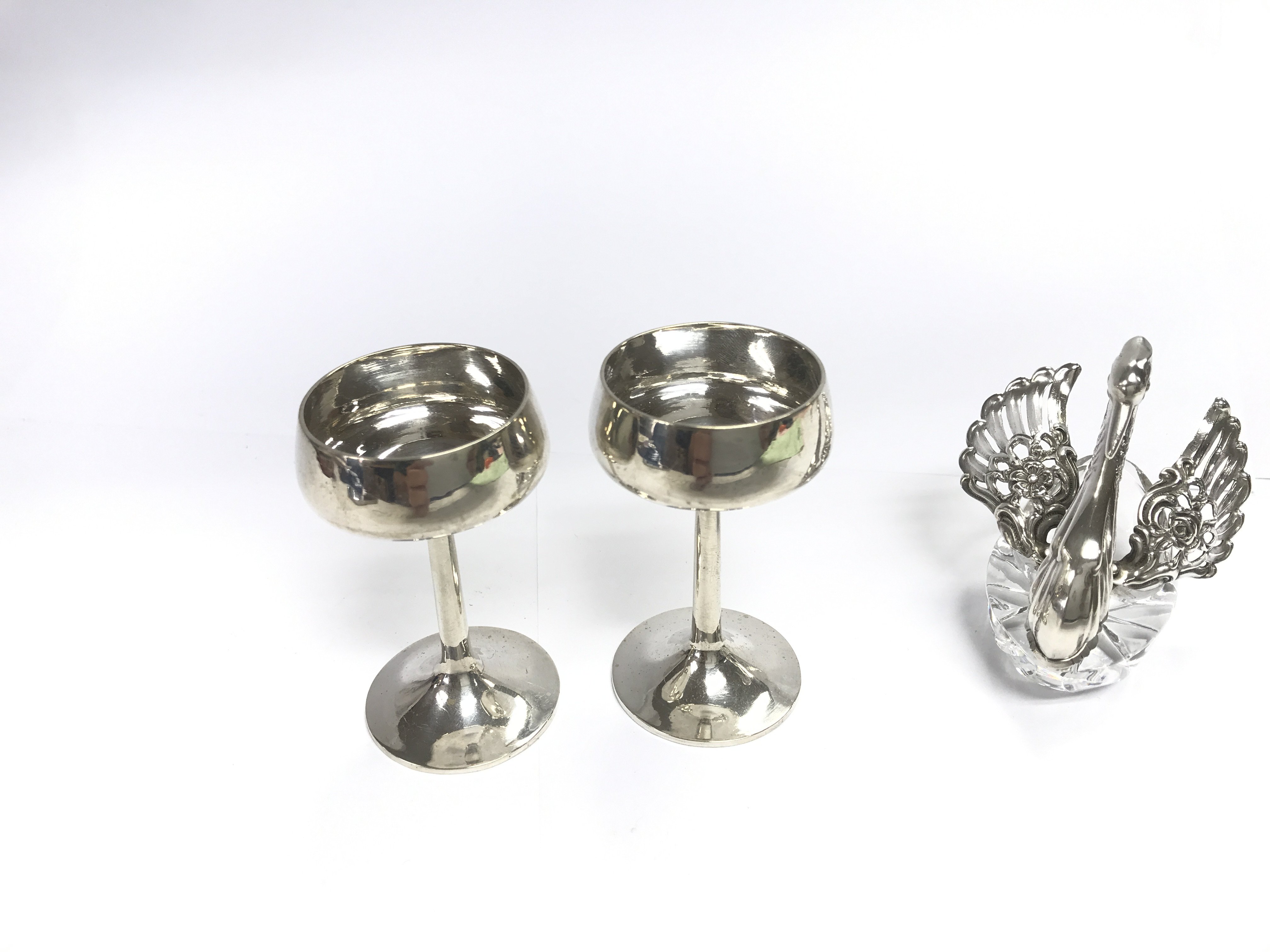 A pair of Chinese silver mini wine cups and a hallmarked silver and crystal swan.