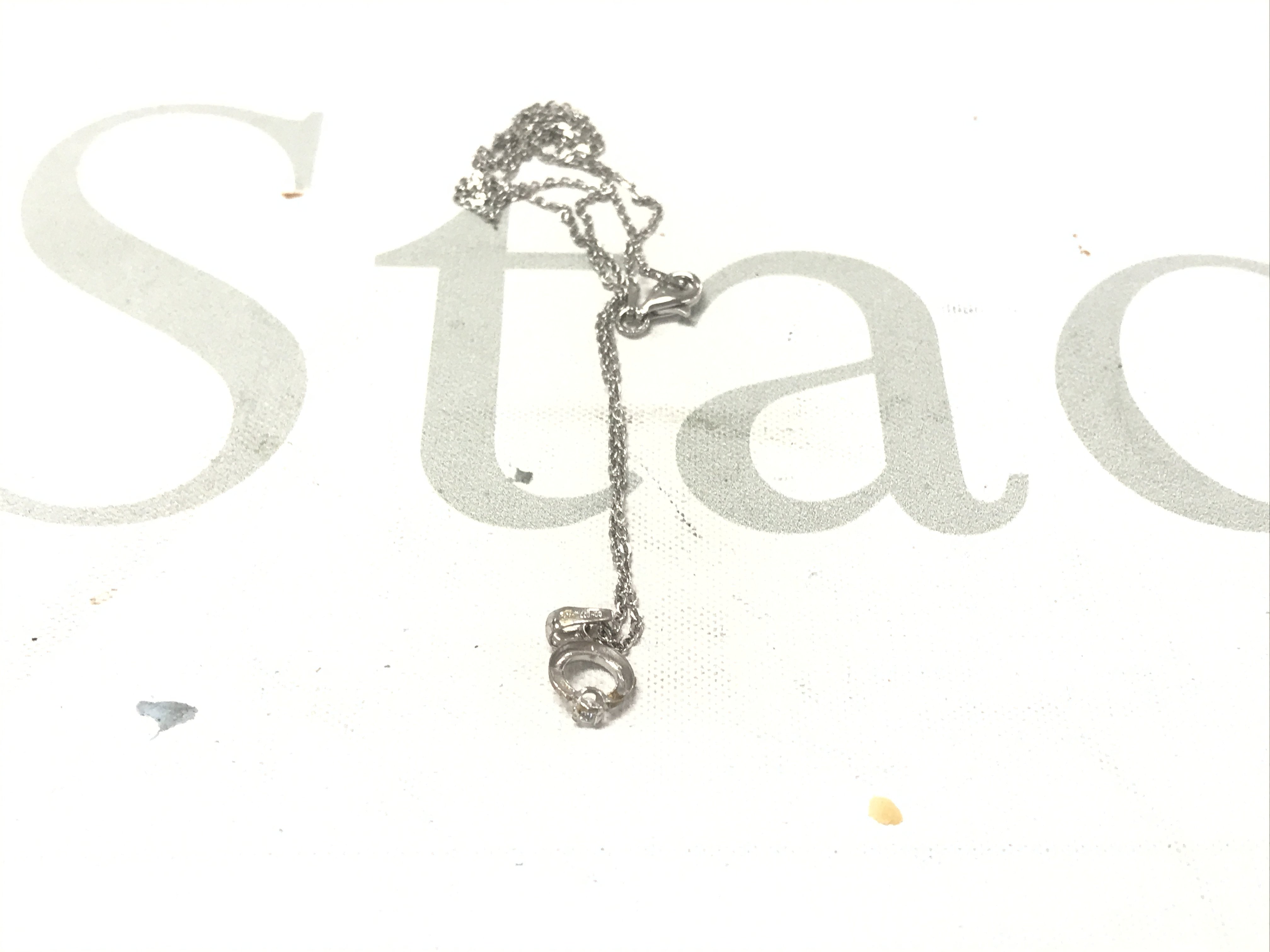 18ct white gold and silver pendant set with a cubic zirconia, on a silver chain.