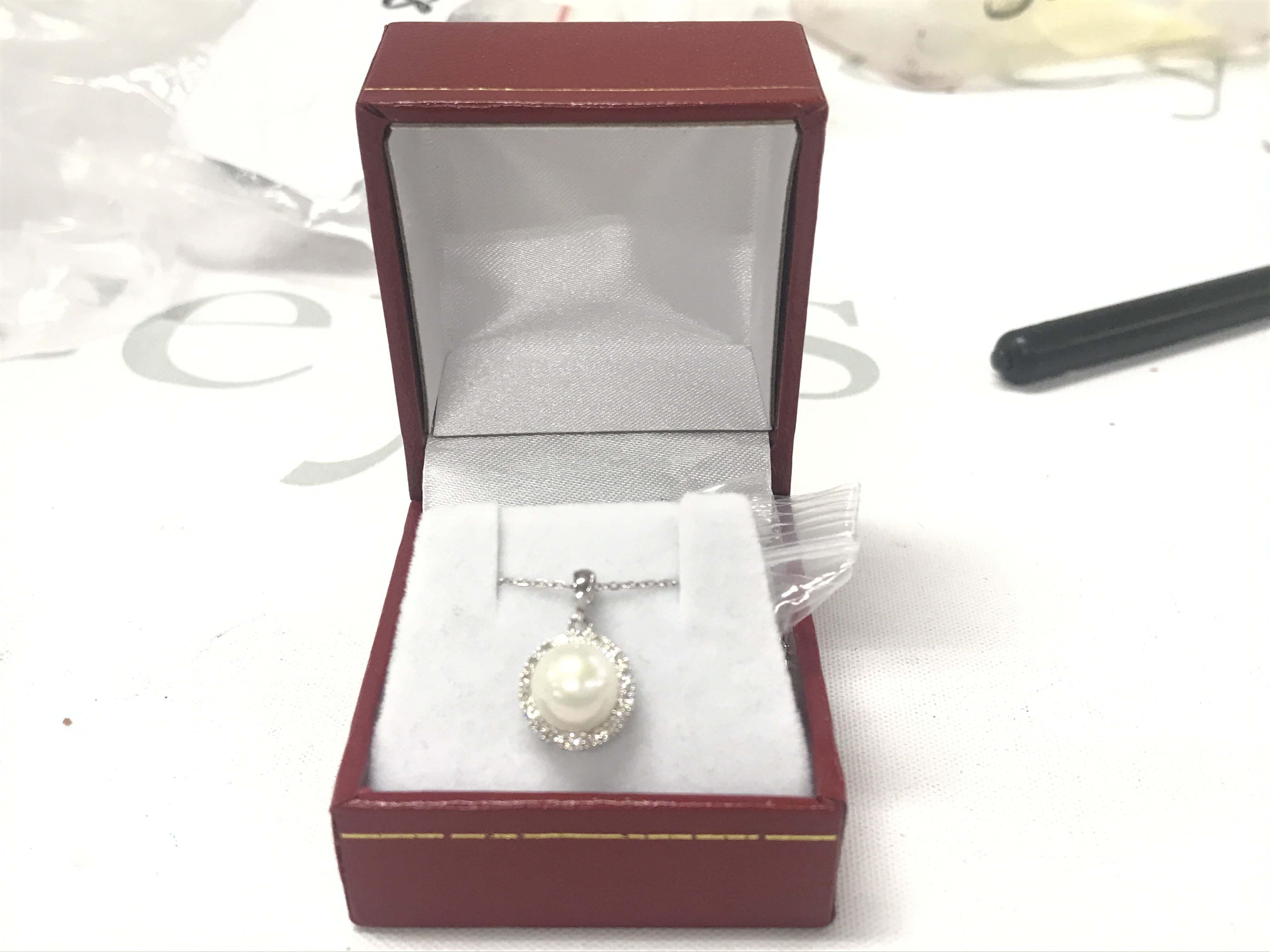 18ct white gold pendant set with a round white cultured pearl and a halo of R/C diamonds, boxed. Diamonds 0.26ct