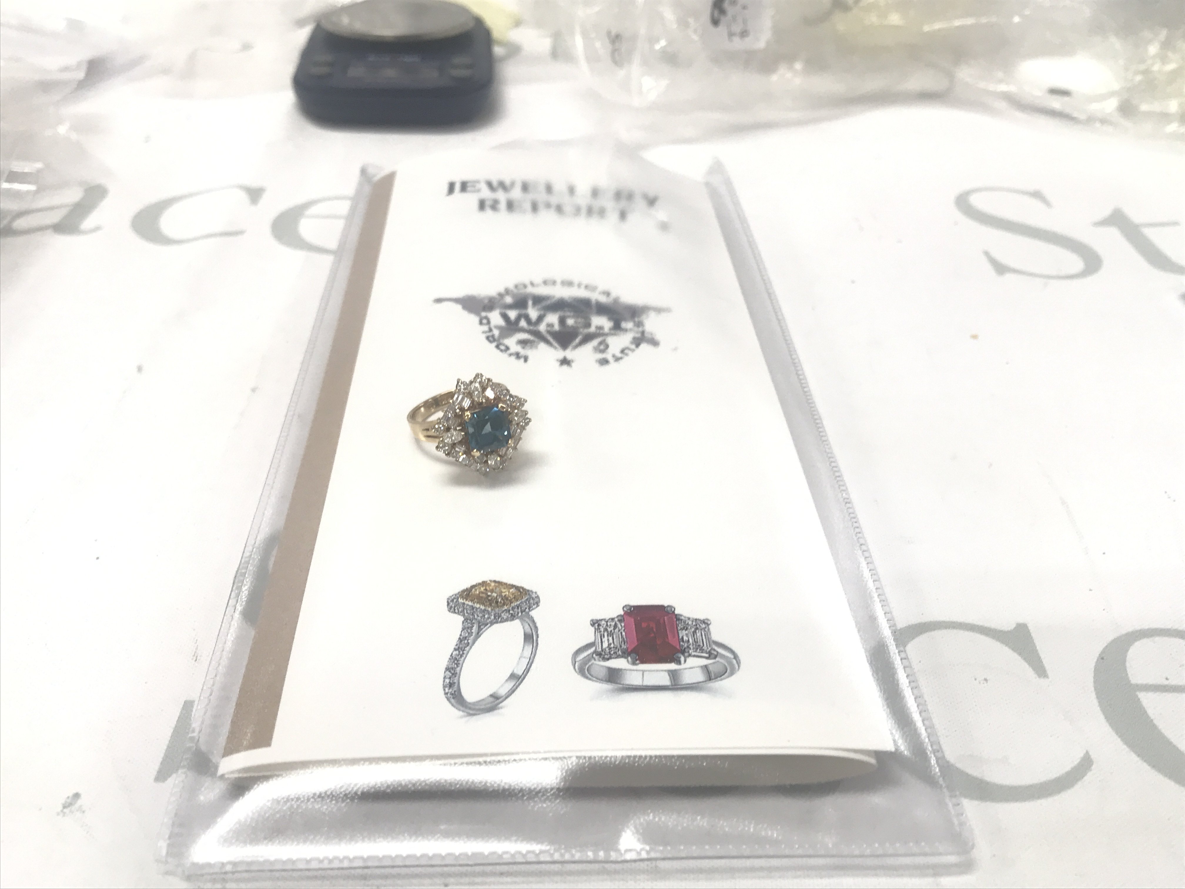 Exciting, certified 18ct yellow gold blue topaz ring with surrounding marquise, baguette and RBC diamonds. Square emerald-cut topaz 3.20ct. Diamonds 1.75ct Cert no. WGI9634154122