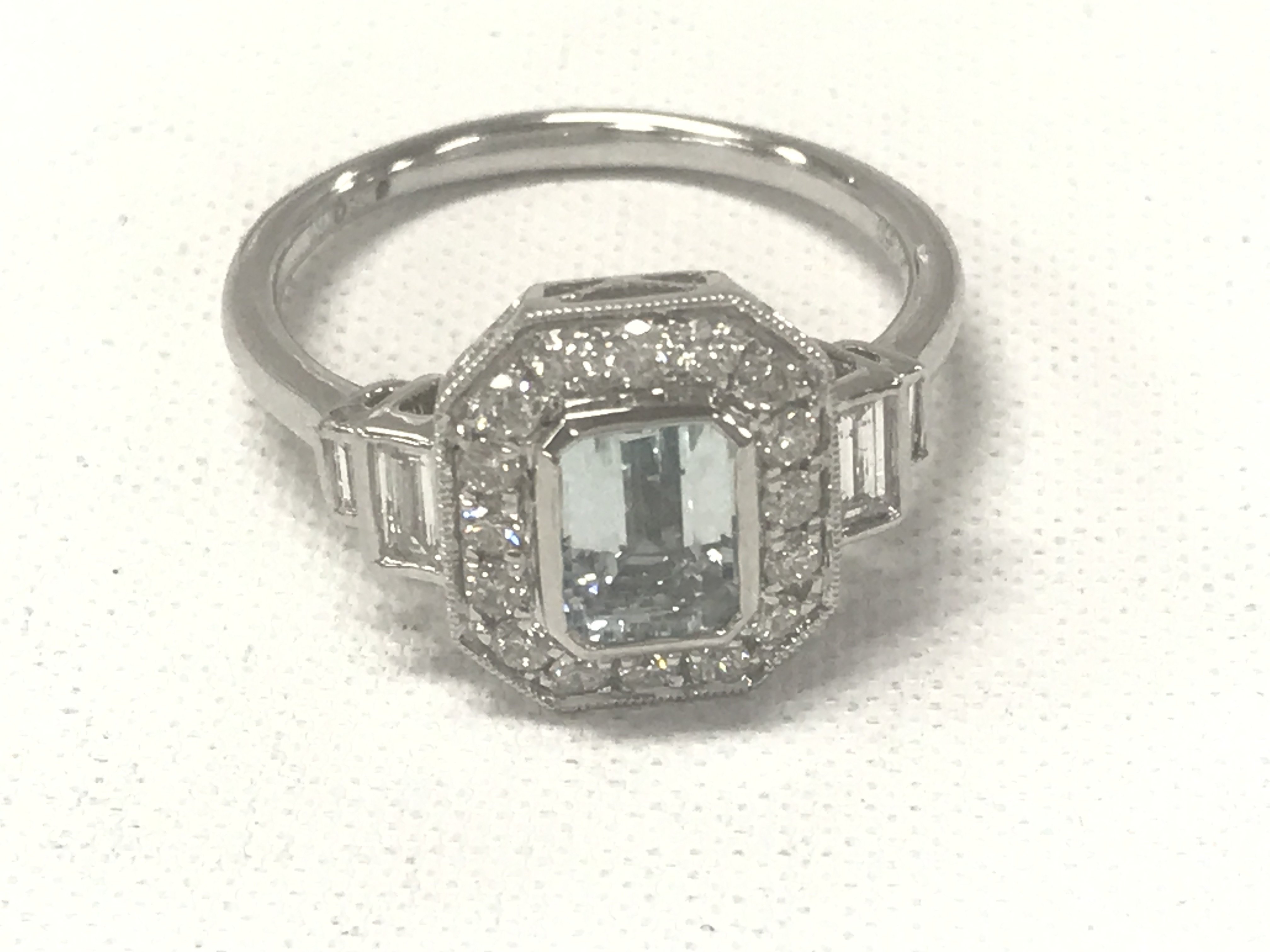 Platinum Art Deco style ring set with a central emerald-cut aquamarine, with RBC and baguette cut diamonds. Aquamarine 0.75ct. Diamonds 0.57ct
