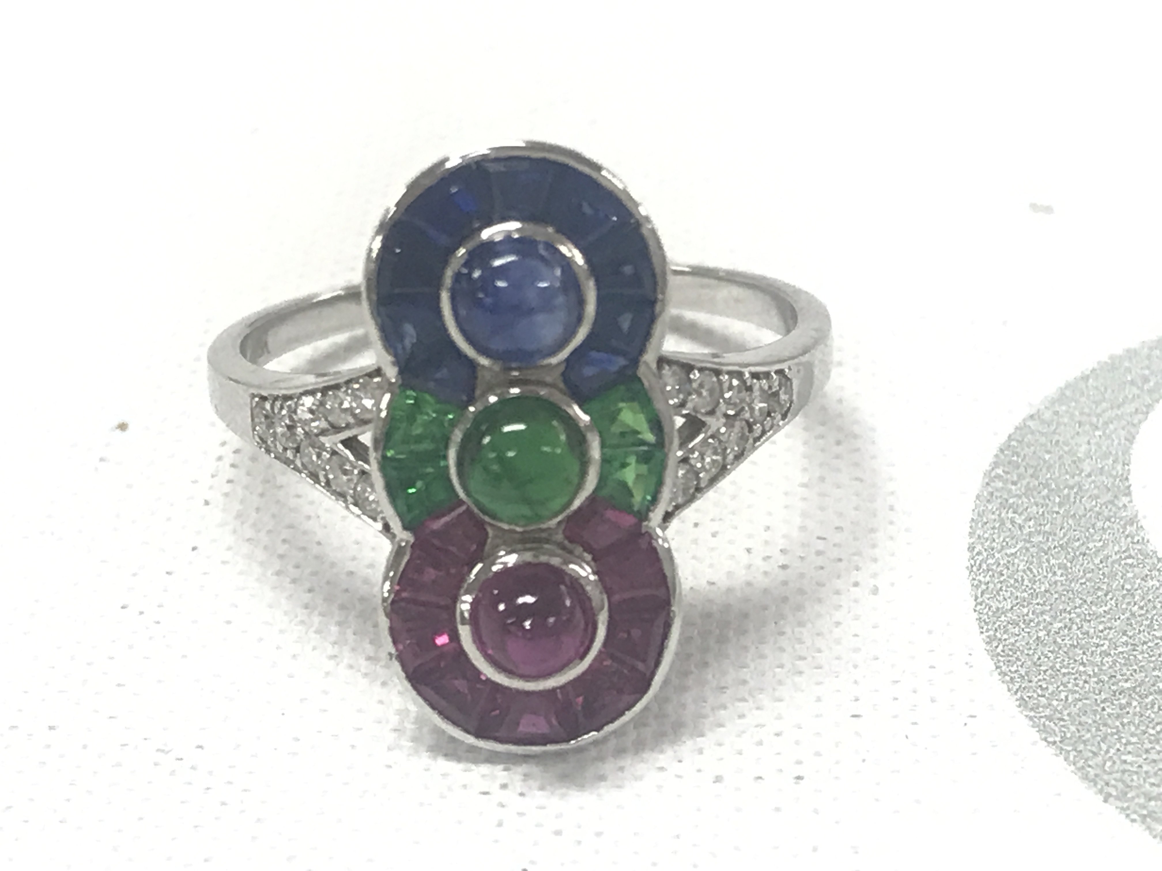 18ct yellow gold Art Deco-style ring set with a cabochon sapphire, ruby and emerald, together with calibre cut sapphires, rubies and emeralds and RBC diamonds. Sapphires 0.32 approx. Rubies 0.35ct approx. Emeralds 0.20ct approx. Diamonds 0.16ct approx.