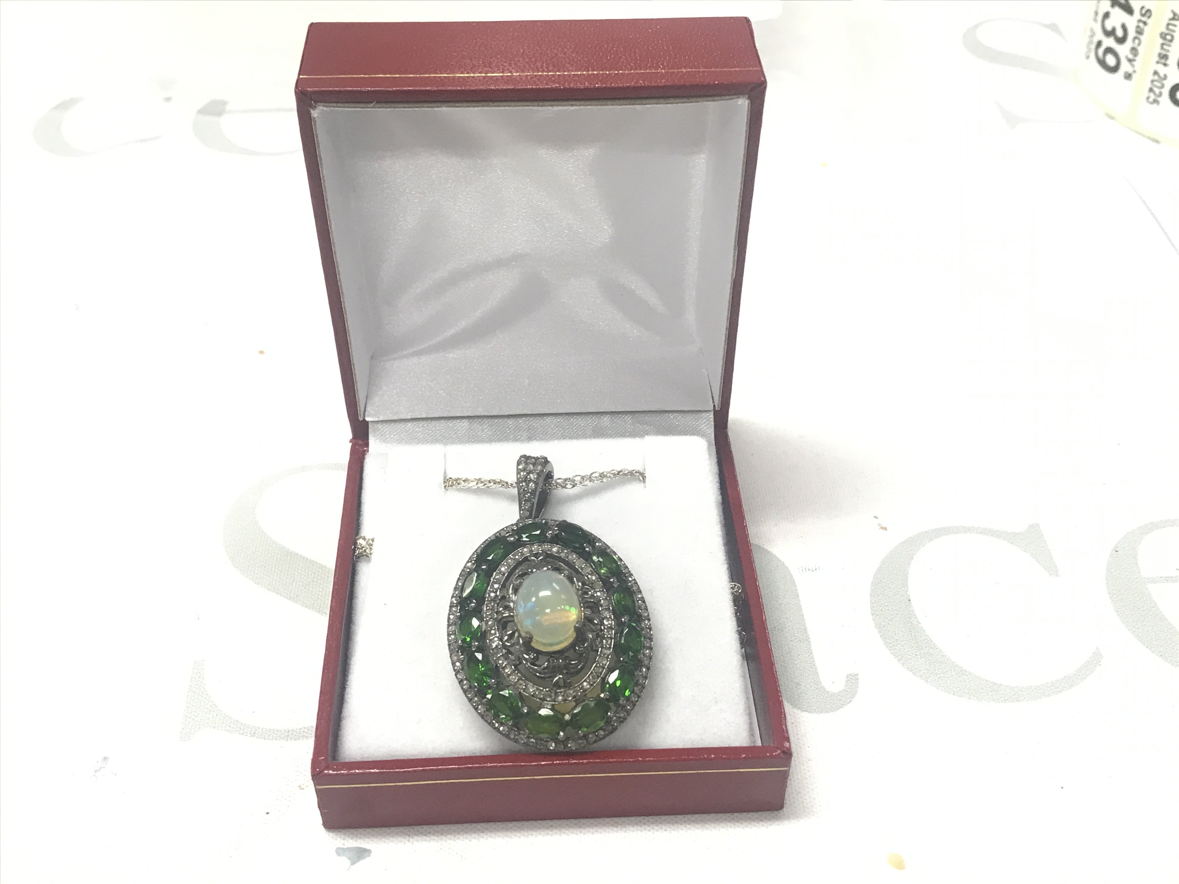 Statement piece pendant set with an oval cabochon opal, chrome diopsides and diamonds in silver, on a silver chain, boxed. Opal 2.00ct approx. Diopsides 3.00ct approx. Diamonds 0.85ct approx.