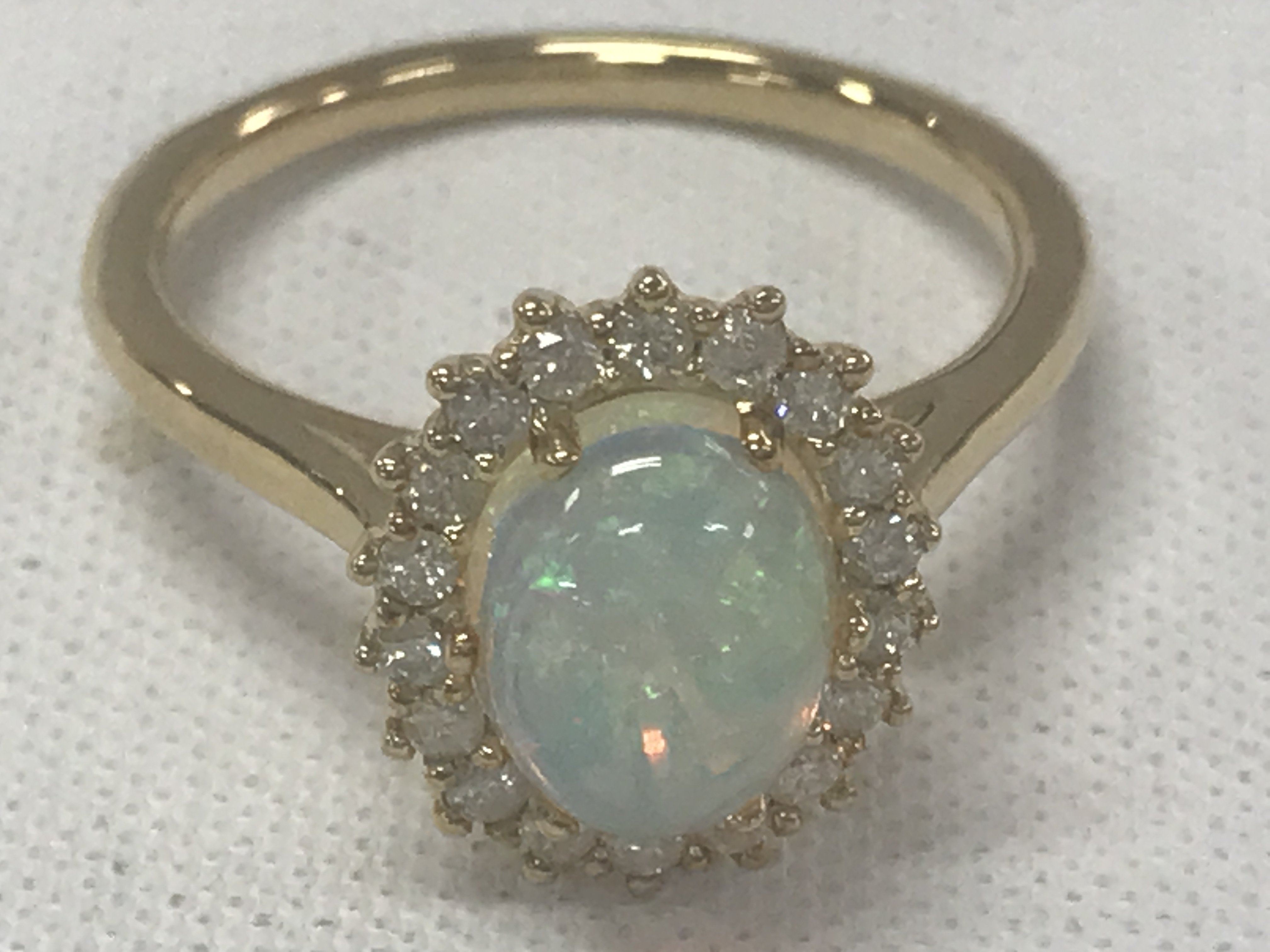 9ct yellow gold oval cabochon opal and RBC diamond cluster ring. Opal 1.16ct. Diamonds 0.30ct.