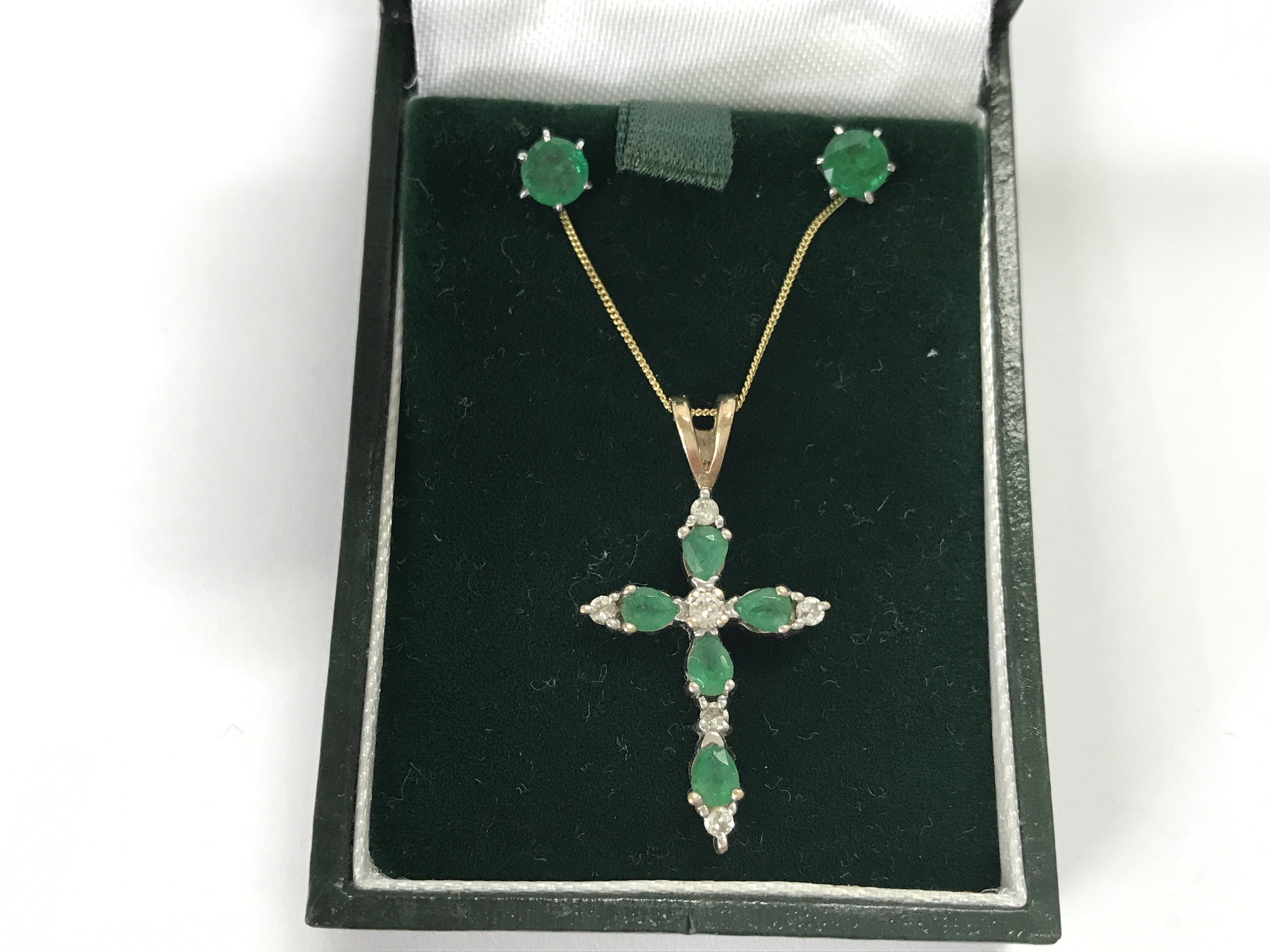 A 14ct gold necklace with emerald and diamond cross and green stone earrings.