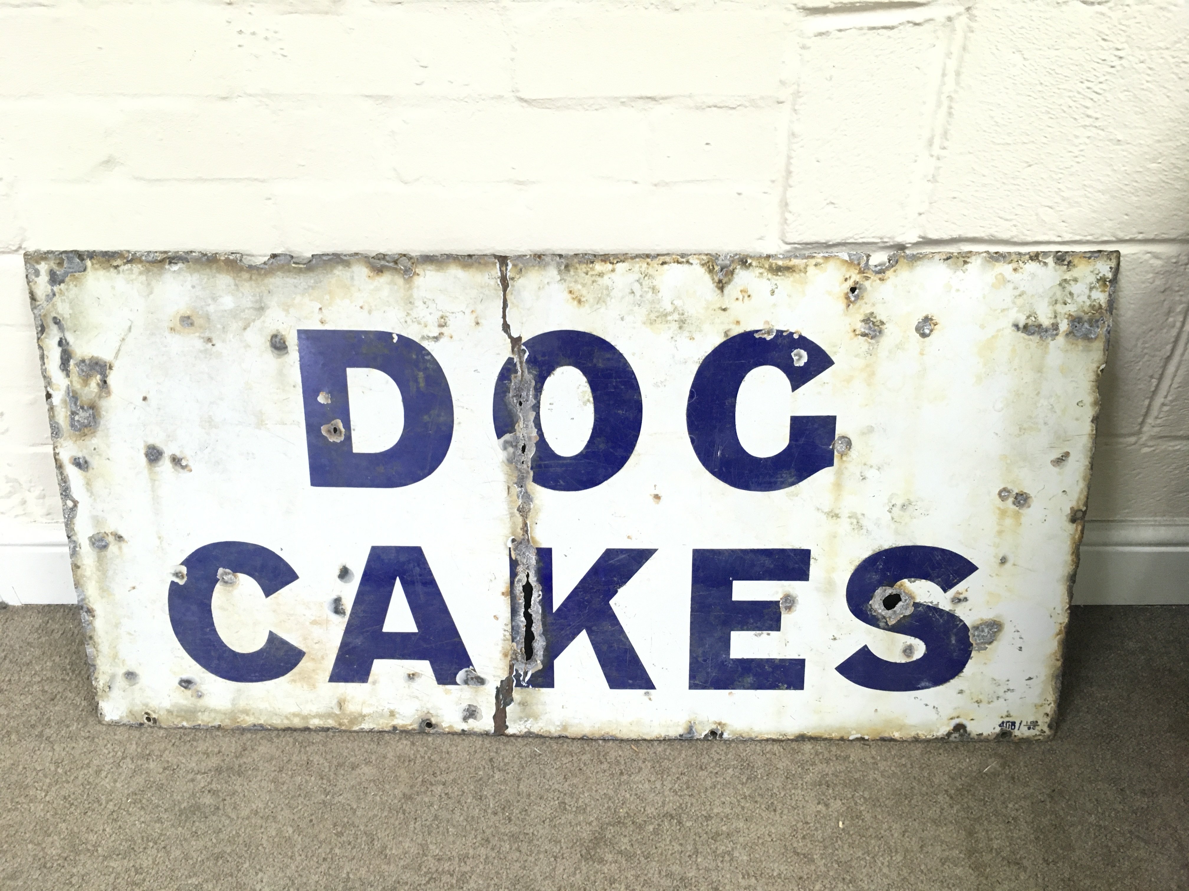 A vintage dog cakes enamel sign.40 x 20 inches approximately