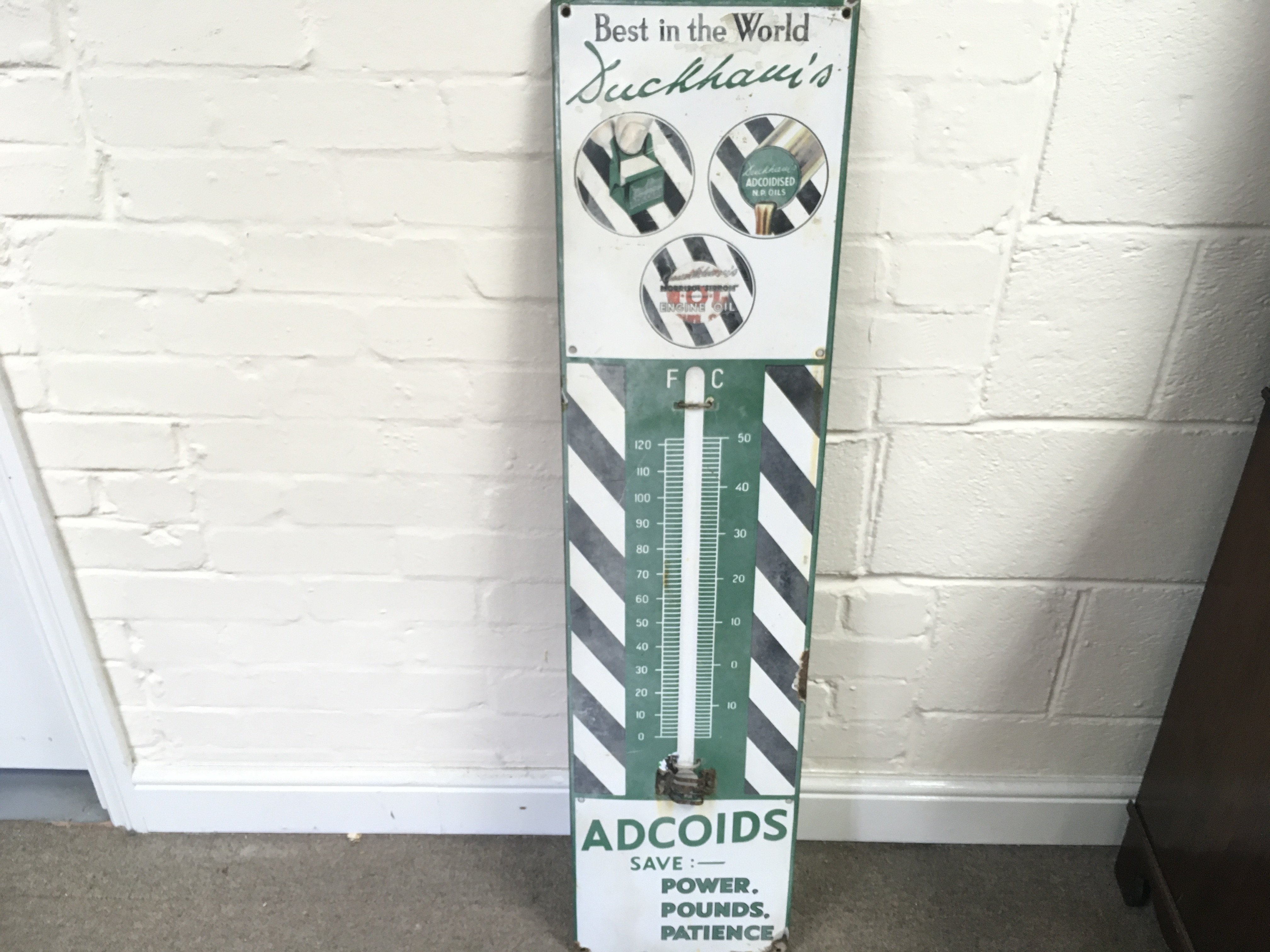An enamel 'Duckhams Adcoids' garage thermometer No glass tube. 11 x 45 inches approximately